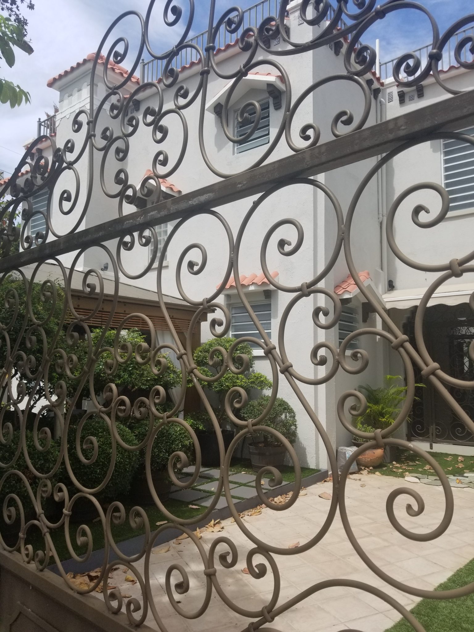 a gate with a white building behind it