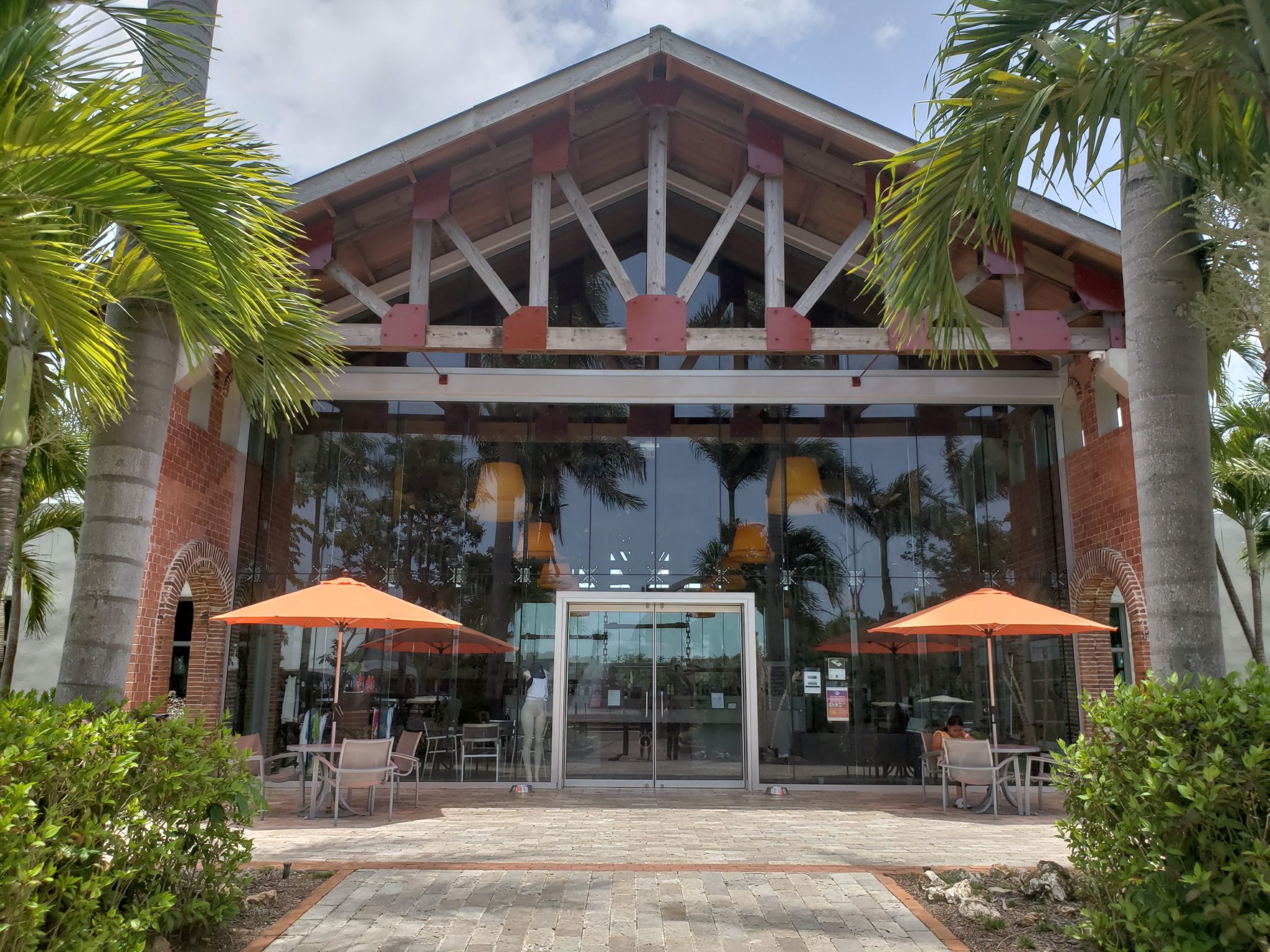 a building with glass doors and orange umbrellas