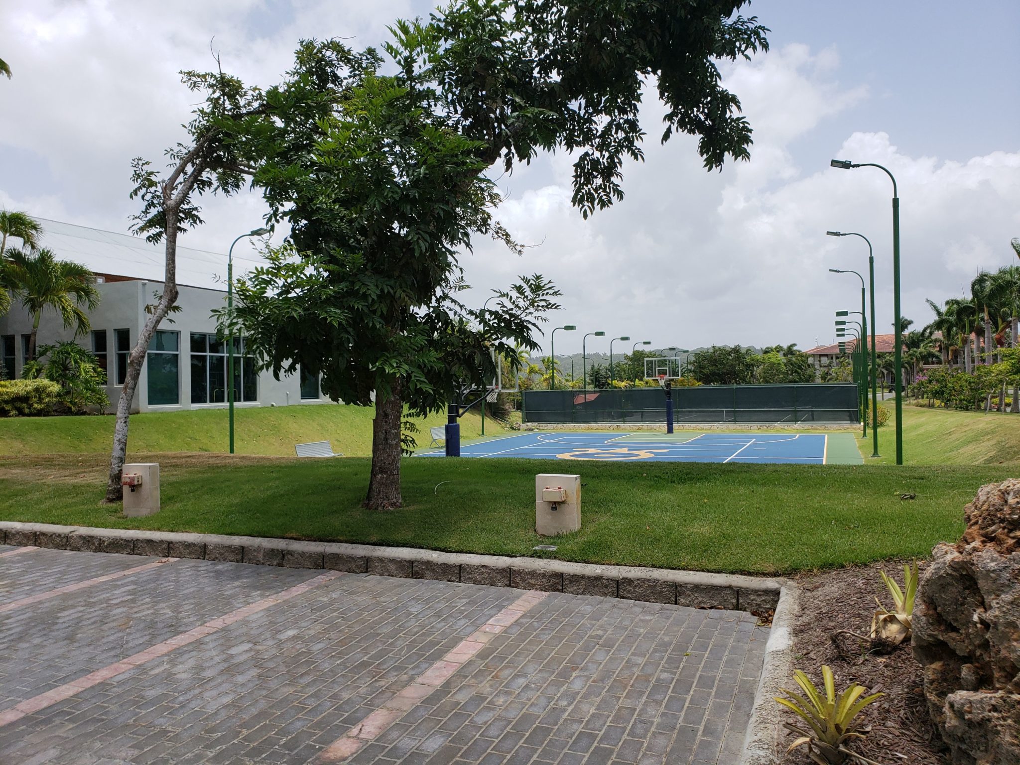 a tennis court with trees and a building