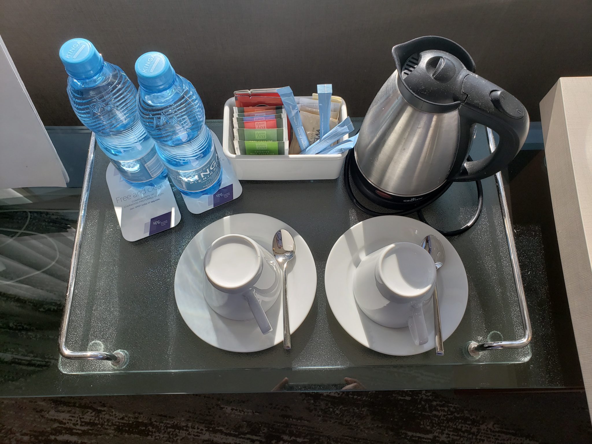 a tray with tea cups and saucers and water bottles