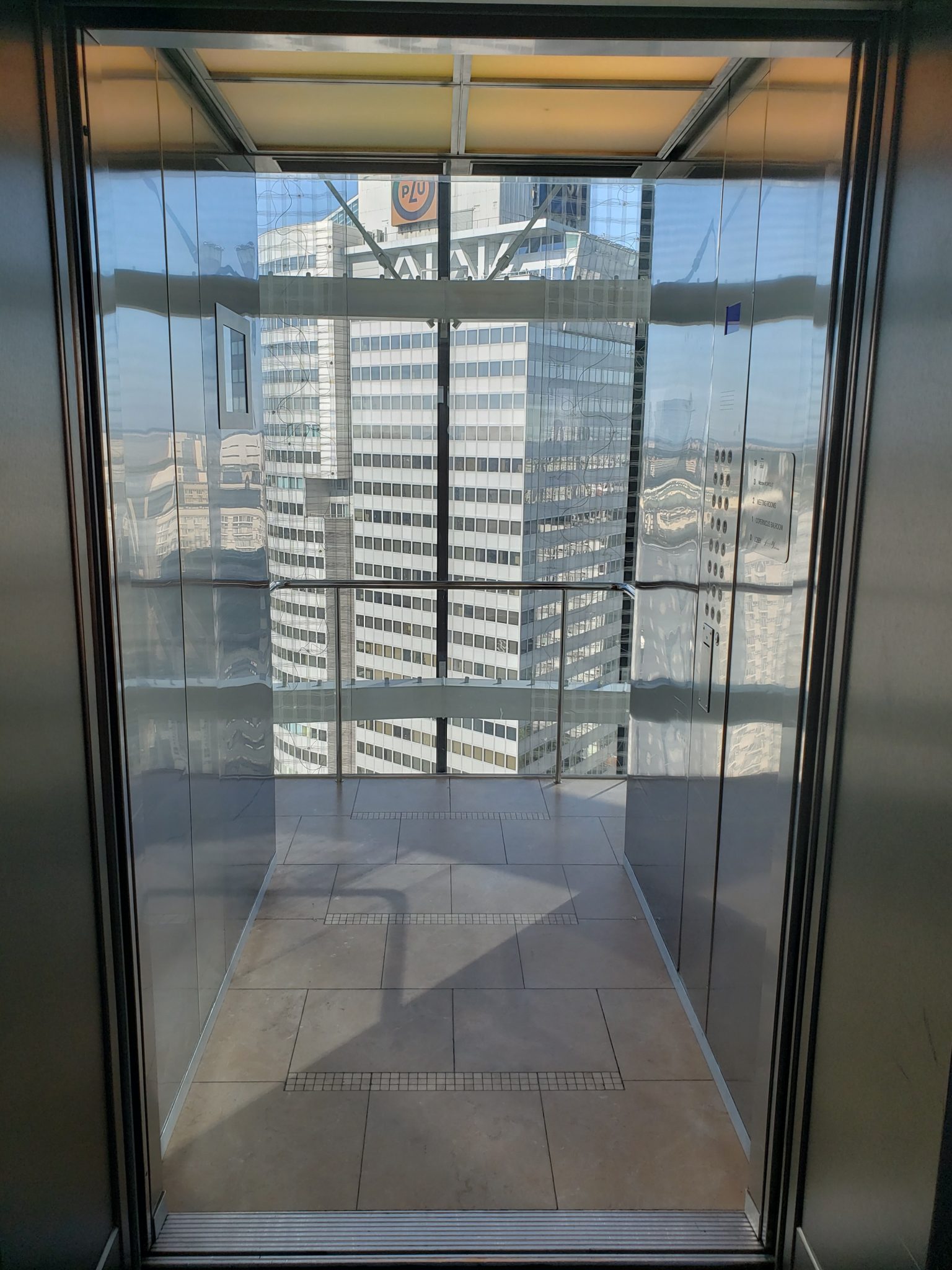 a glass elevator with a view of a city