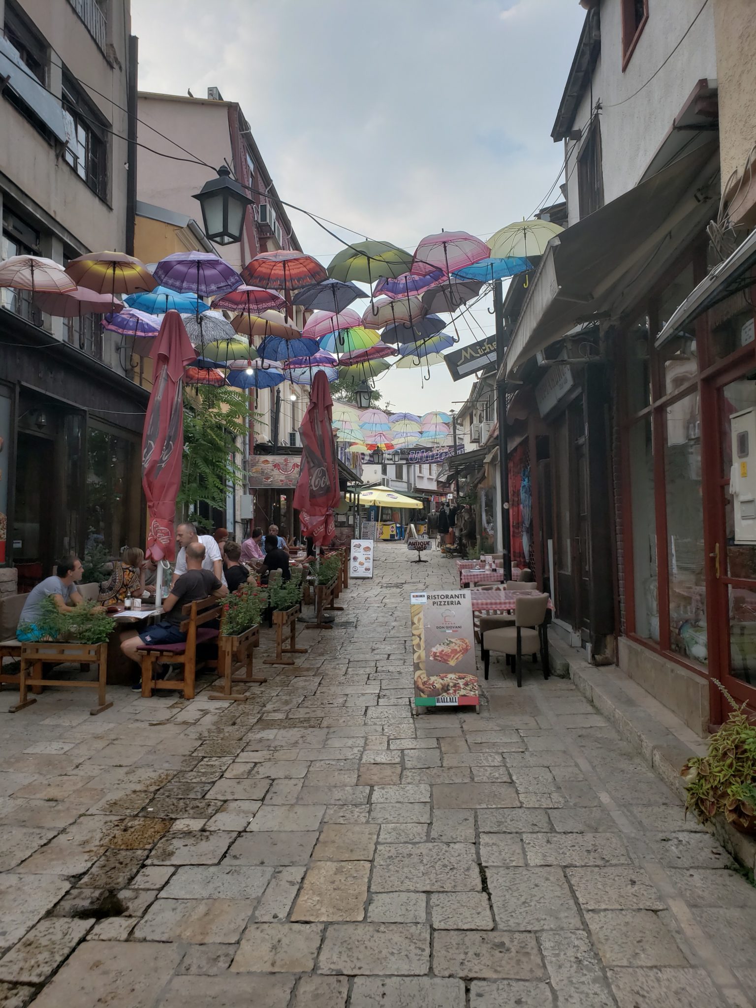 a street with tables and umbrellas over it