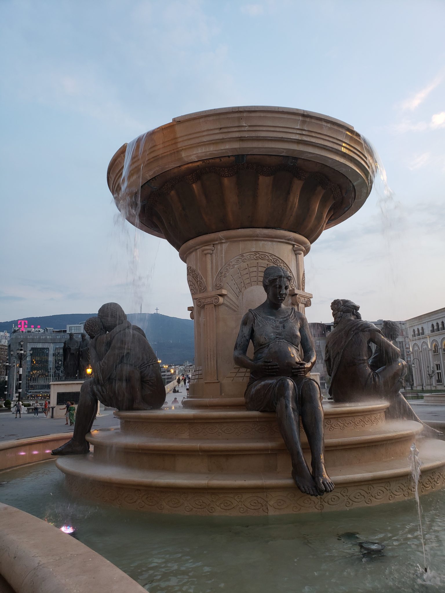 a fountain with statues of people sitting on it