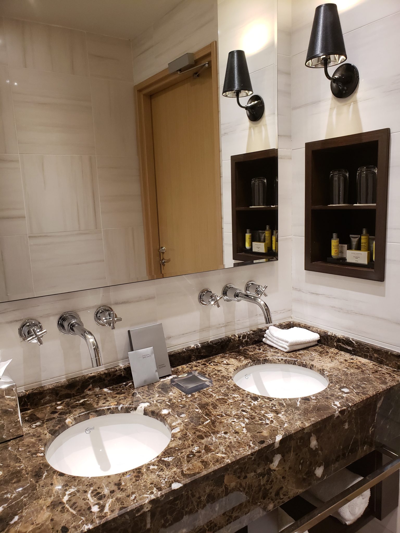 a bathroom with marble countertop sinks and a door