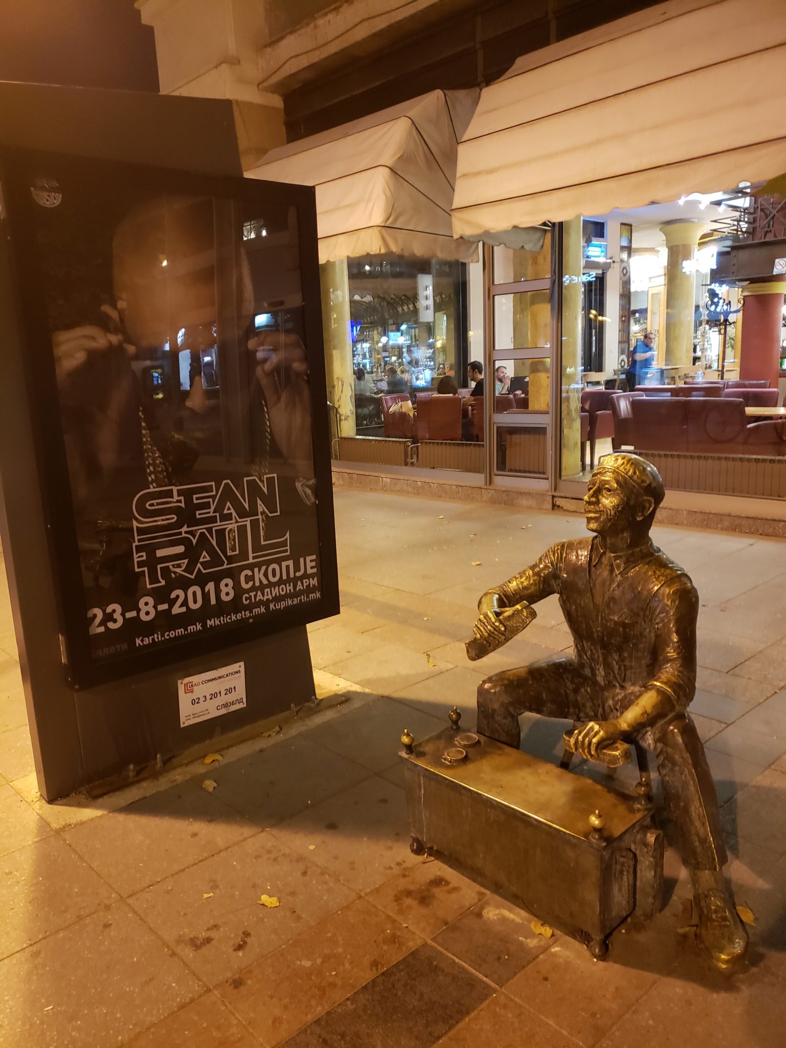 a statue of a man sitting on a suitcase