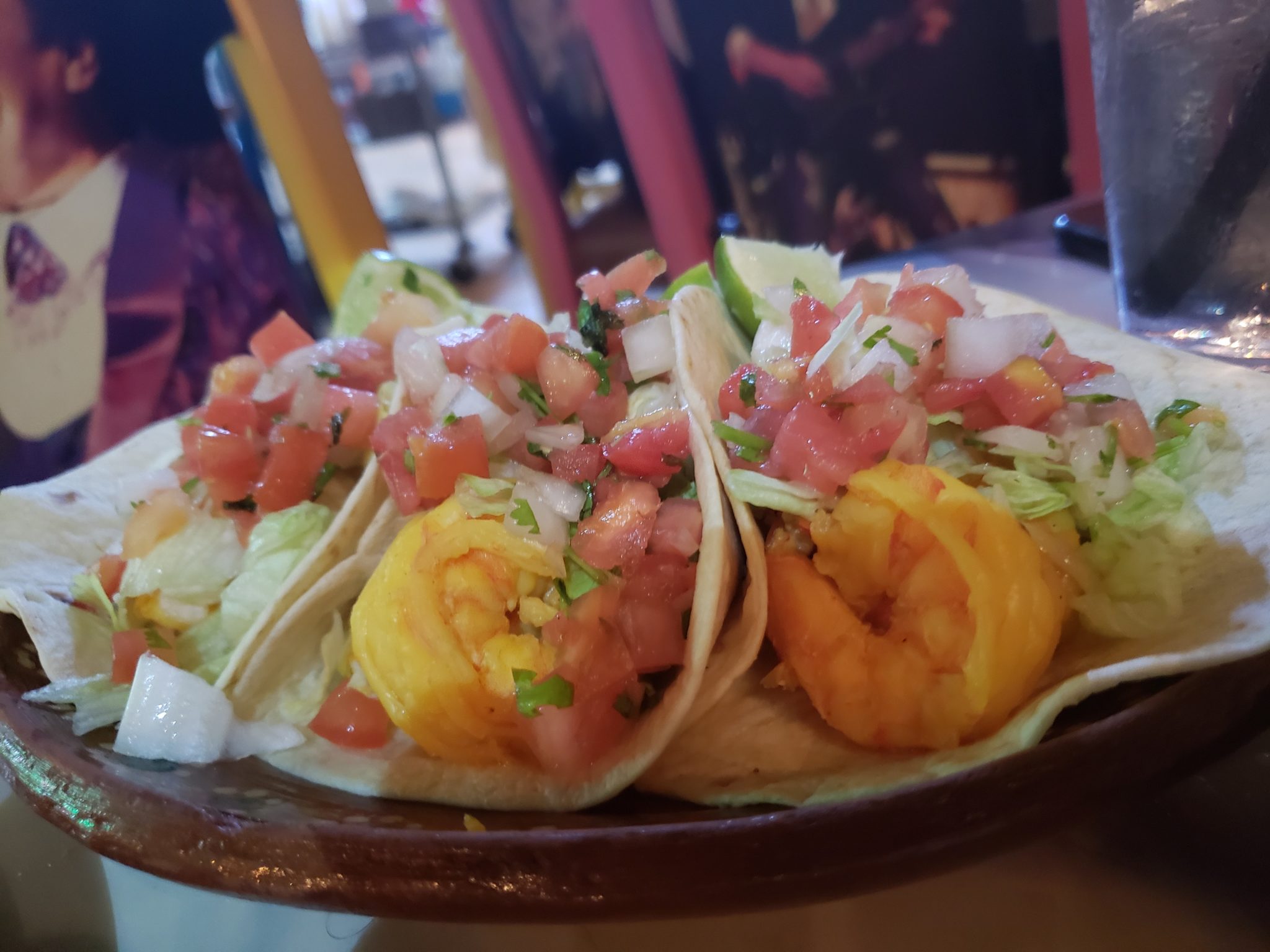a plate of tacos with shrimp and salsa