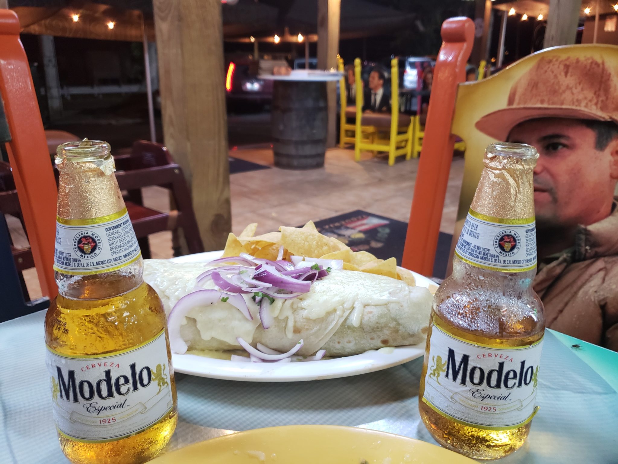 a burrito and beer bottles on a table