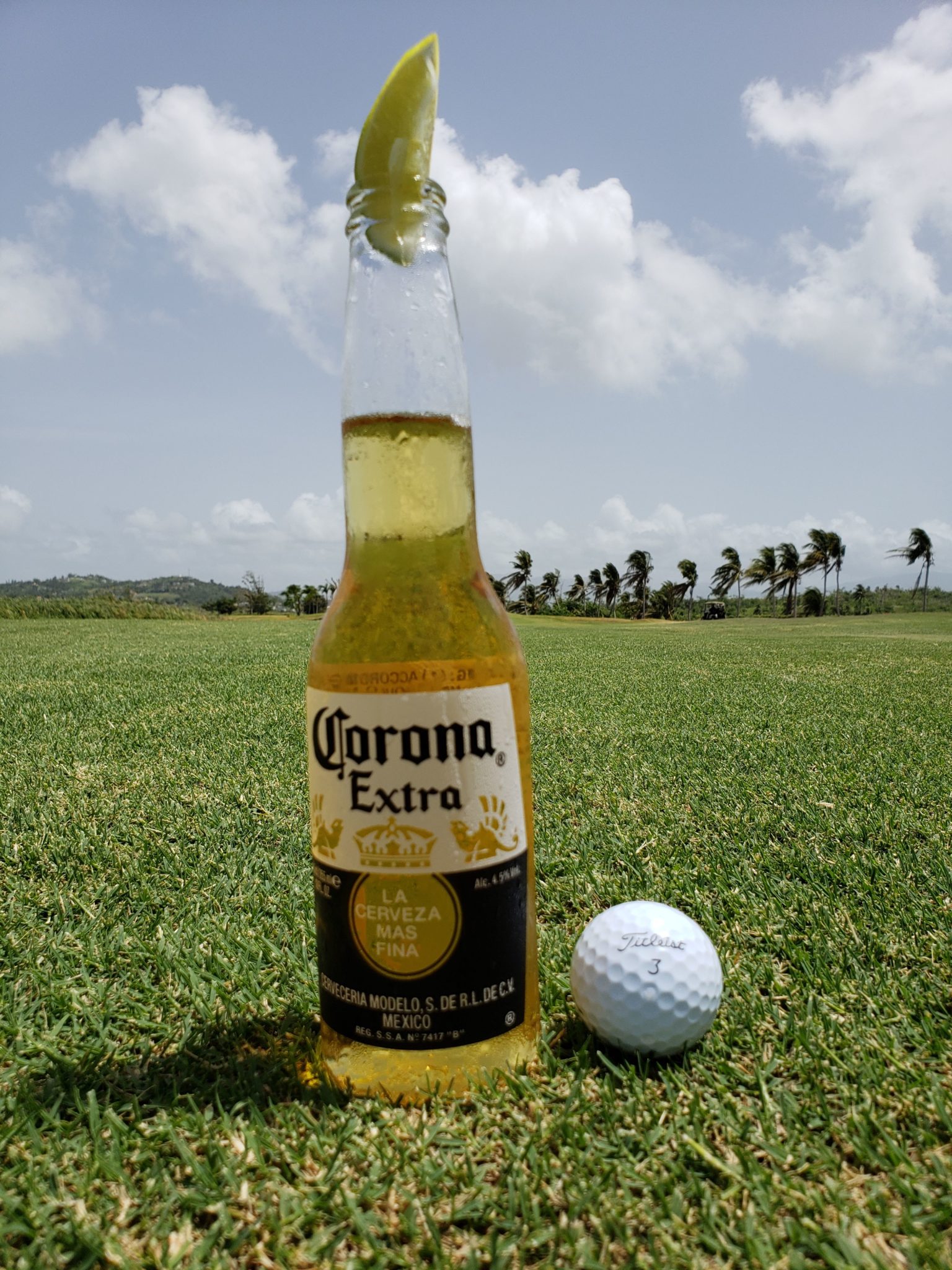 a beer bottle and golf ball on a golf course