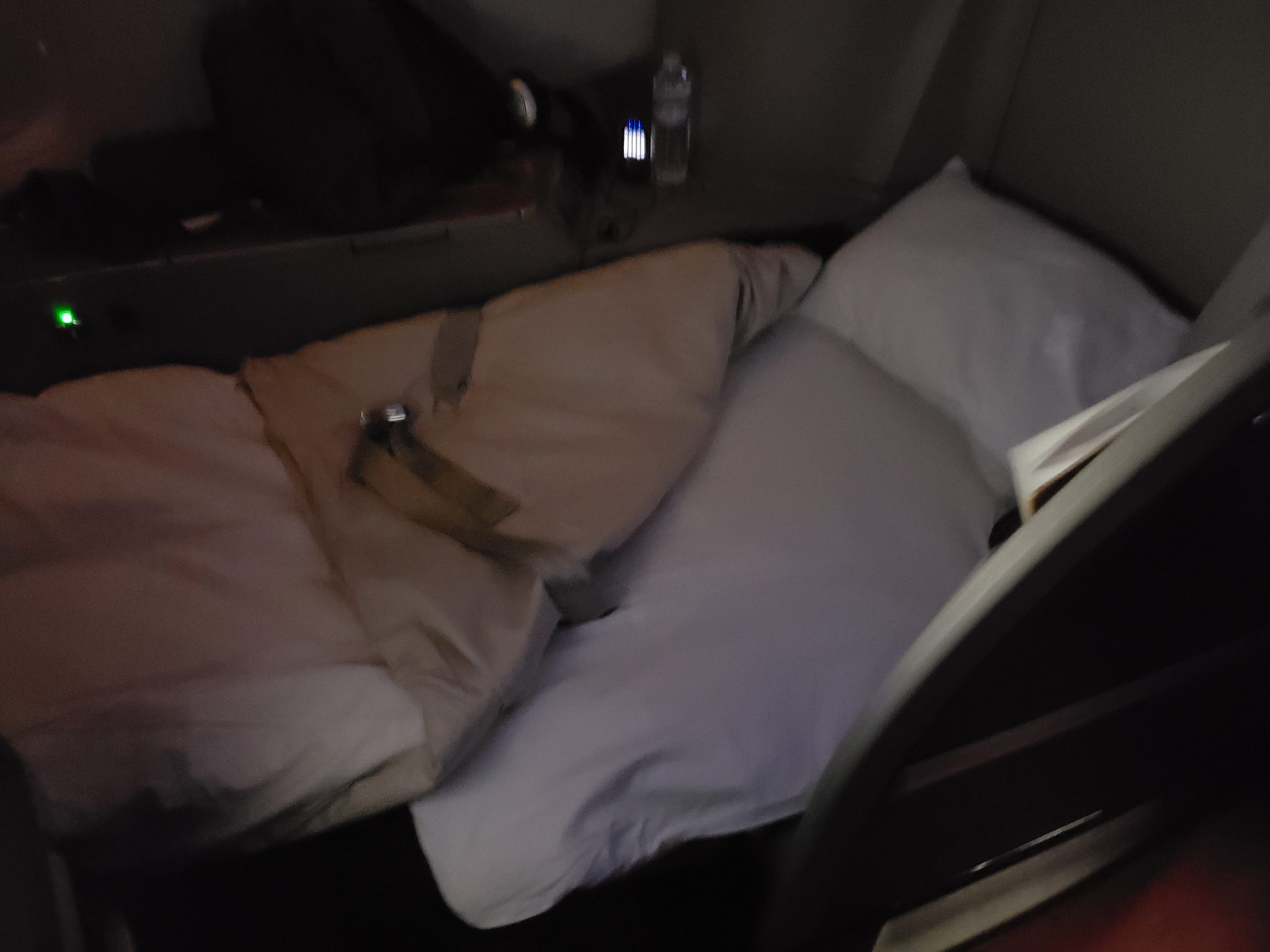 a bed with a pillow and a seat belt