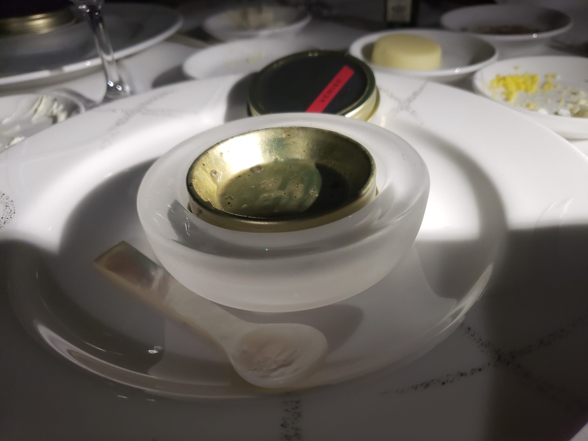 a plate with a glass bowl and a spoon on it