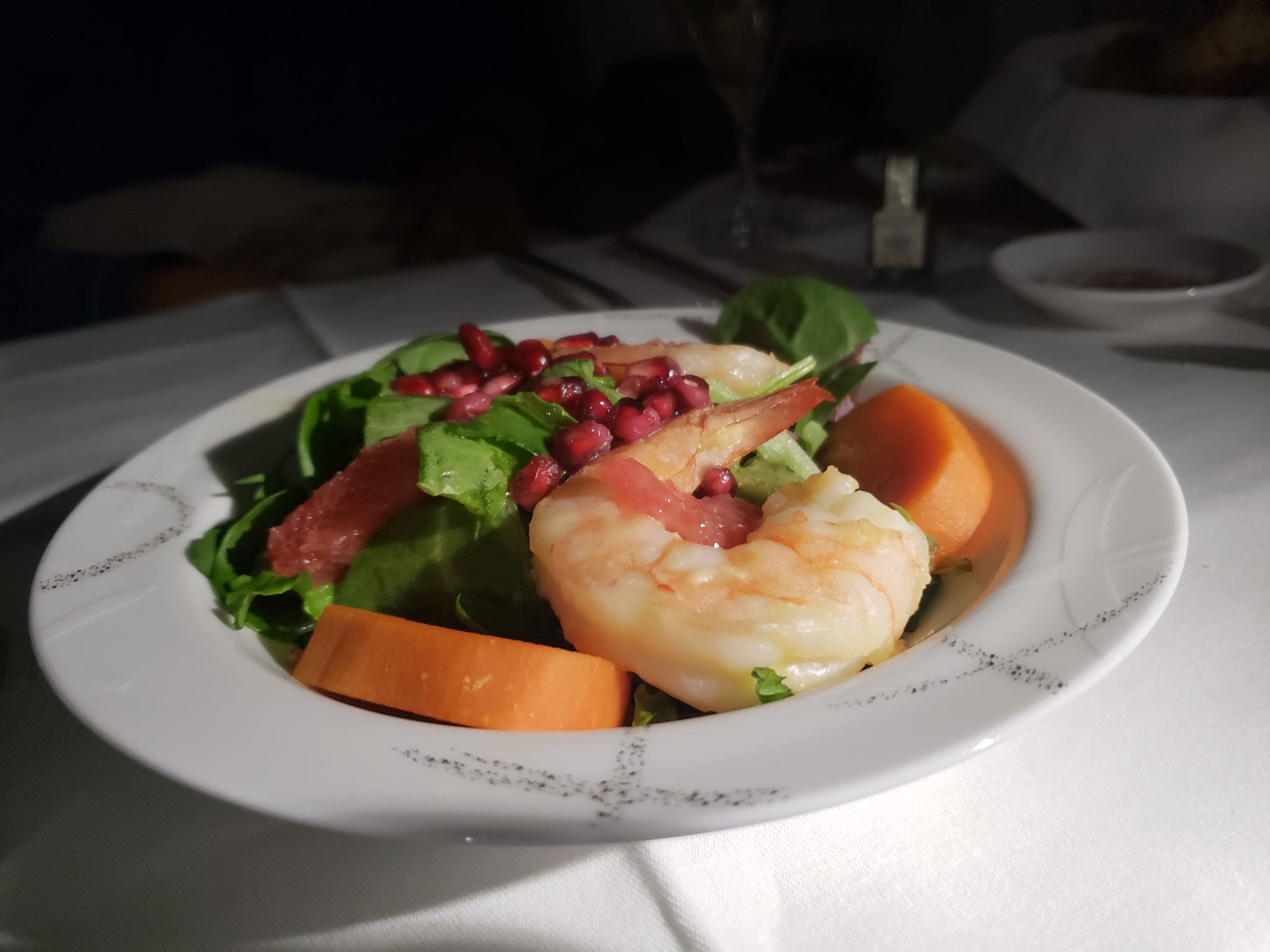 a plate of salad with shrimp and vegetables