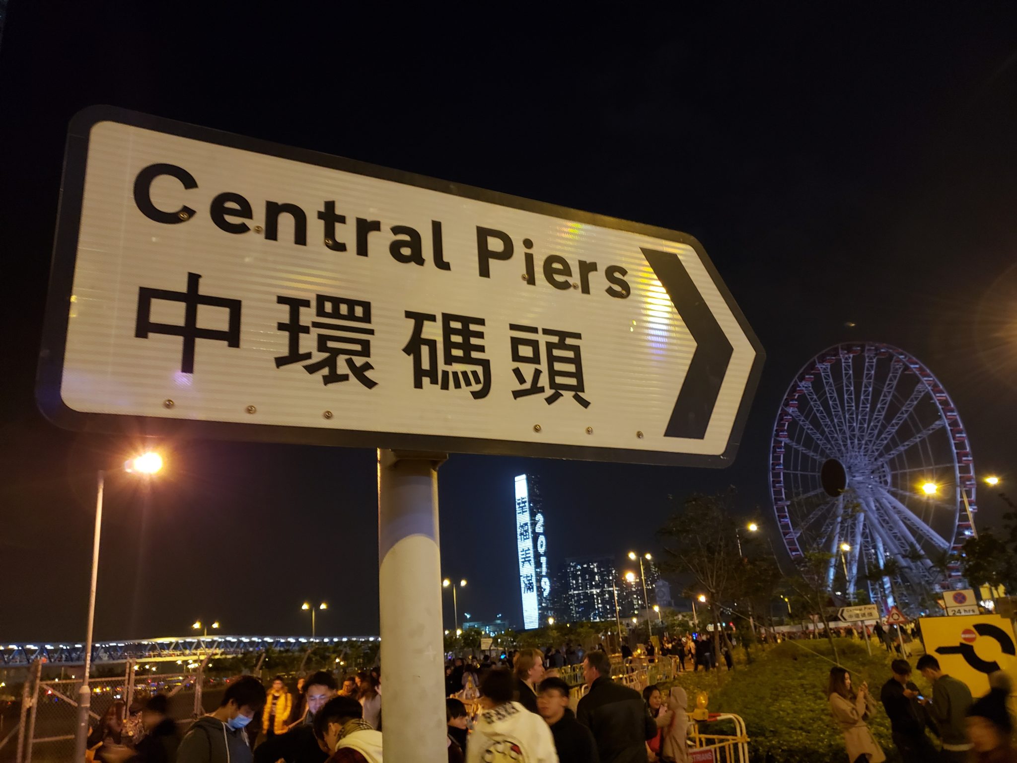 a sign with a ferris wheel in the background