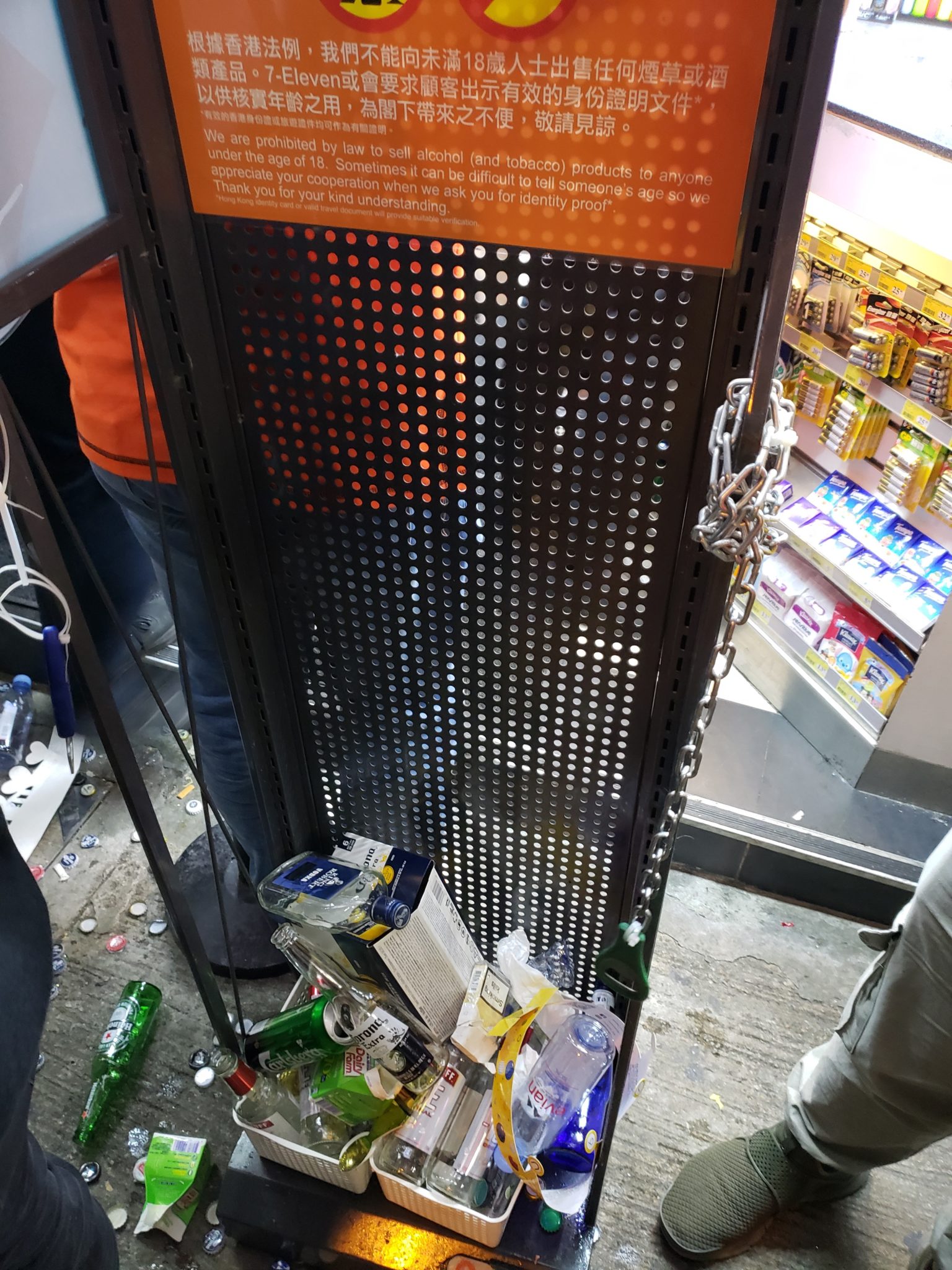 a metal screen with a chain and bottles on it