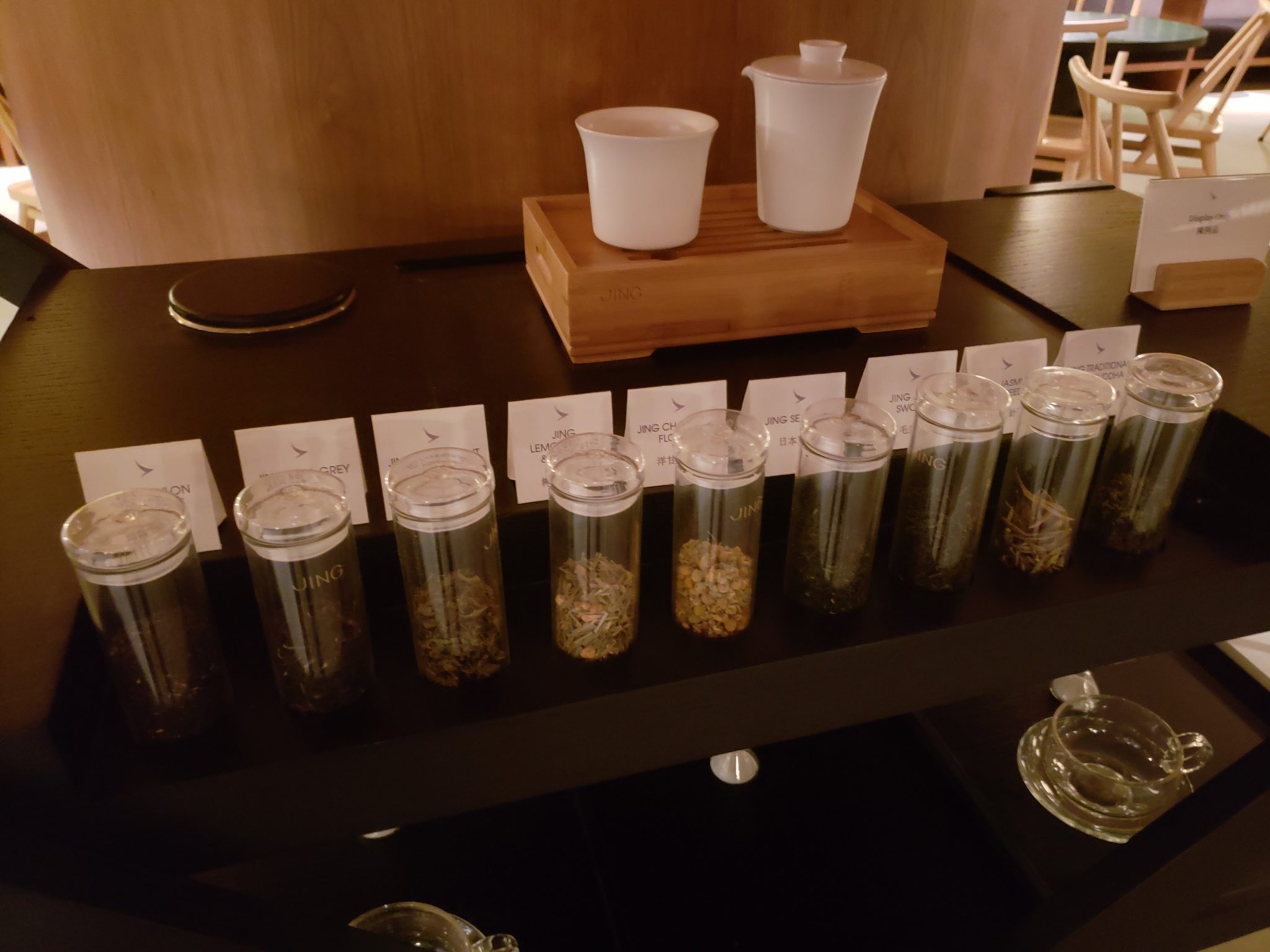 a row of glass containers with different herbs on a table