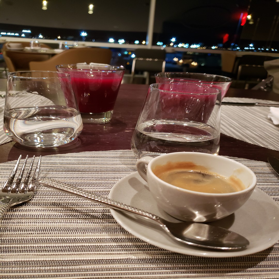 a table with a cup of coffee and glasses