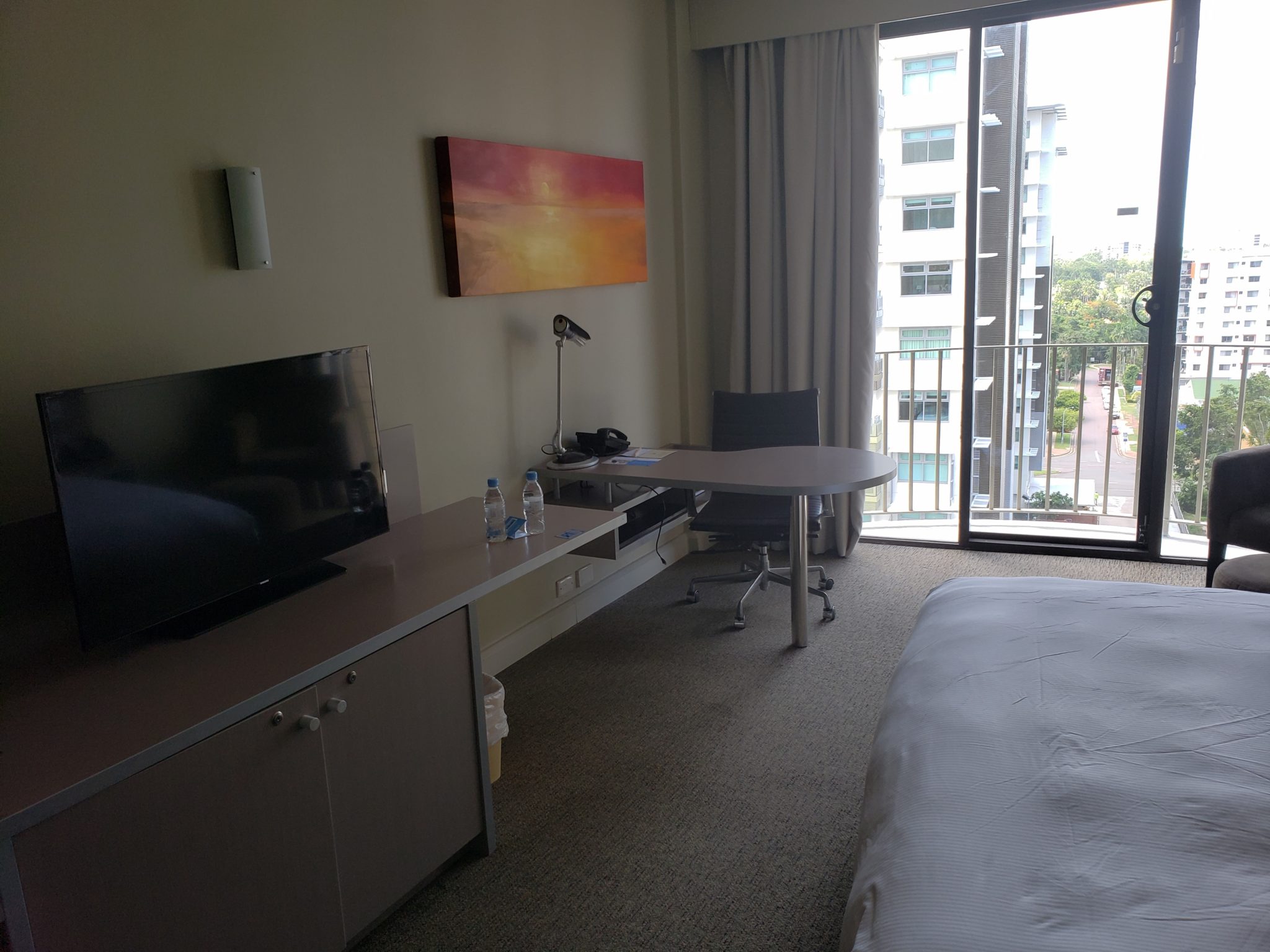 a room with a bed and a desk and a television