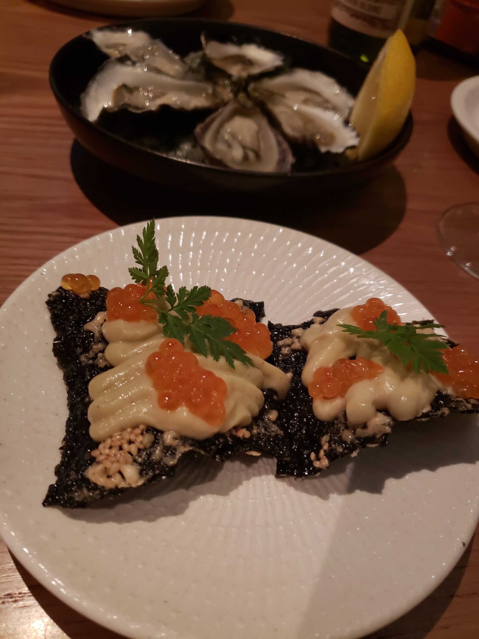 food on a plate next to a bowl of oysters