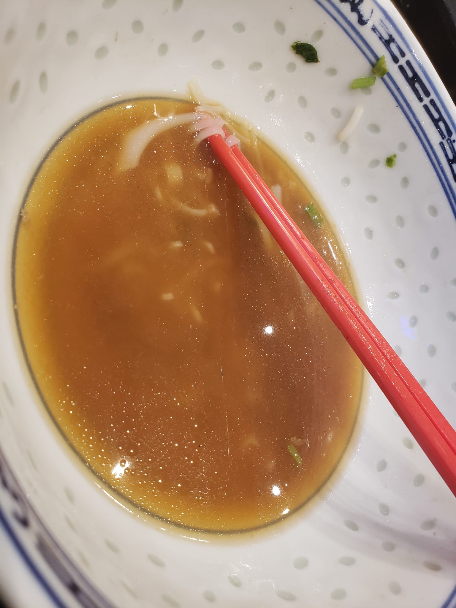 a bowl of soup with chopsticks