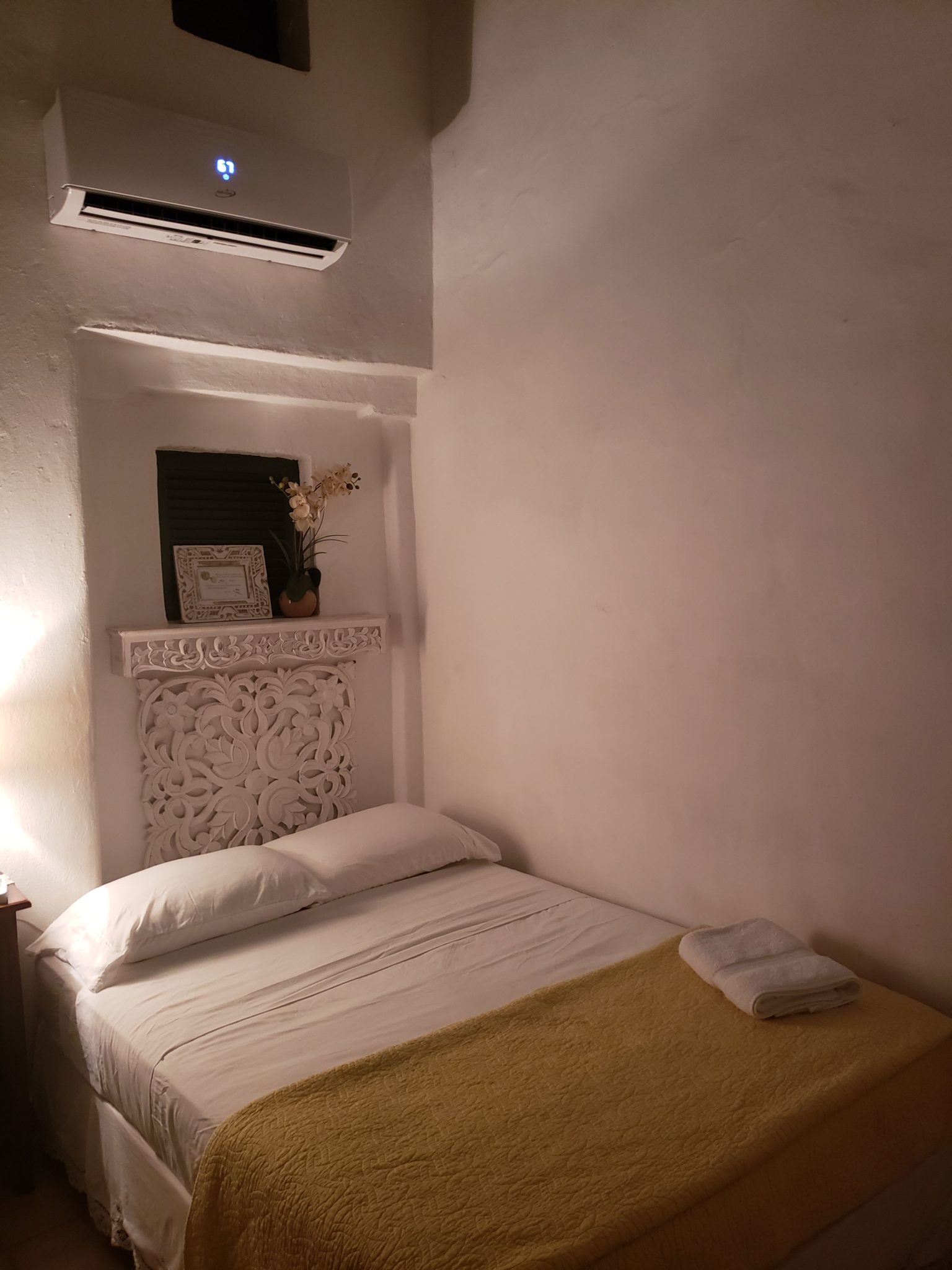 a bed with a air conditioner above it