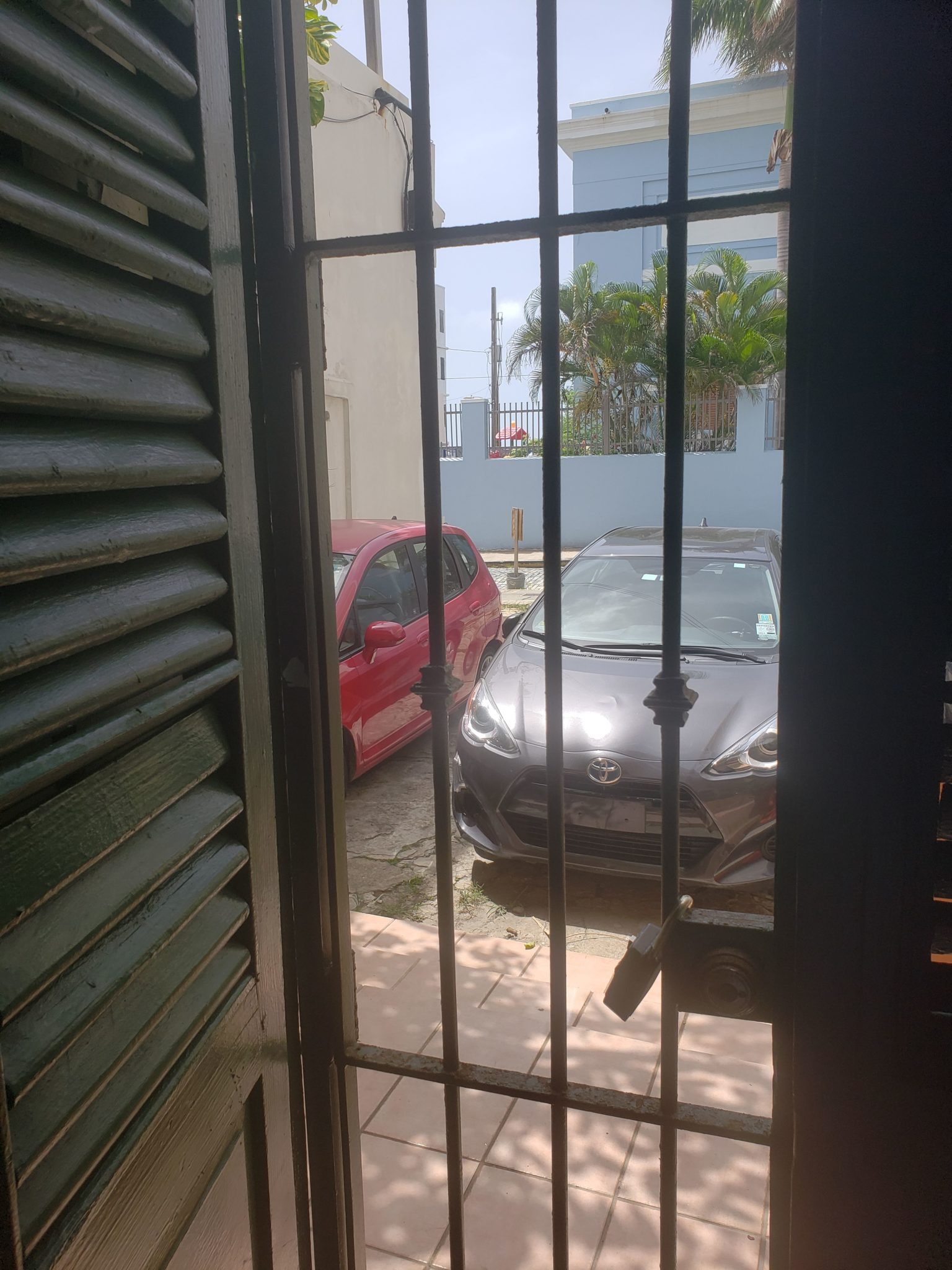 a door with bars and a car parked in a parking lot