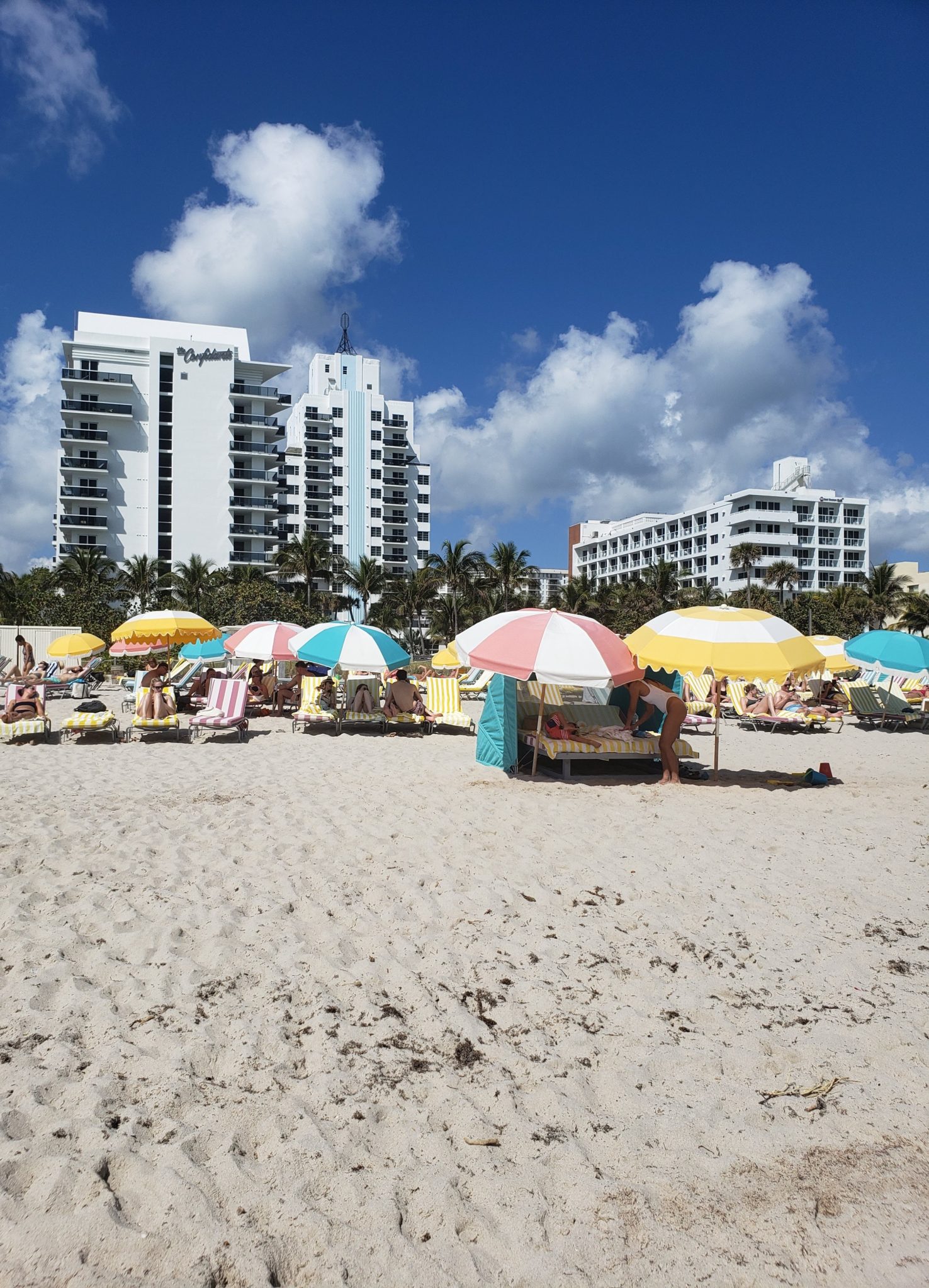 a group of people on a beach with umbrellas and chairs