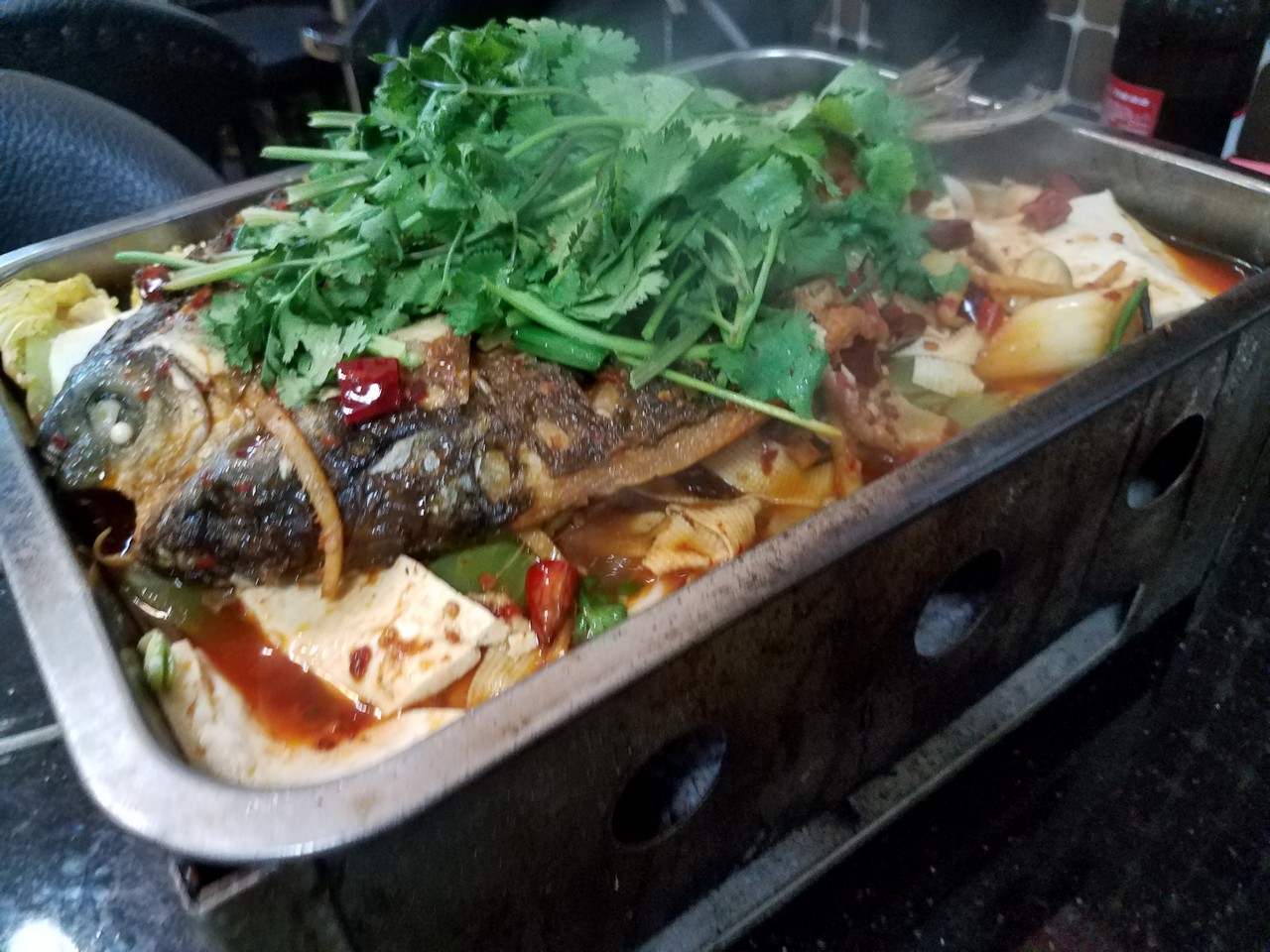 a fish with vegetables in a pan