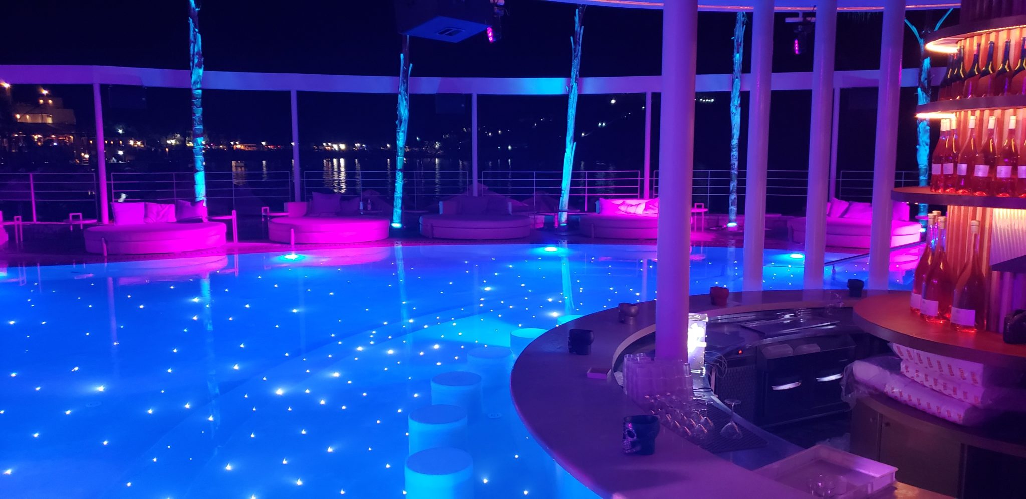 a pool with lights and a bar