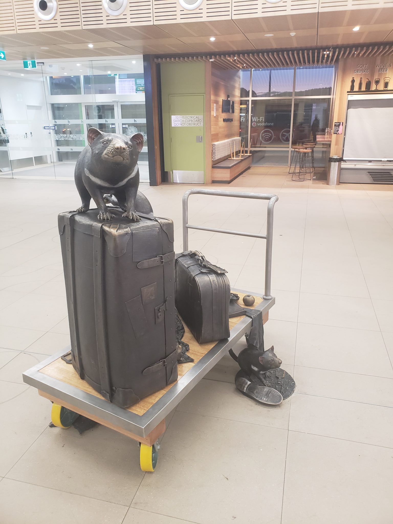 a rat statue on top of luggage