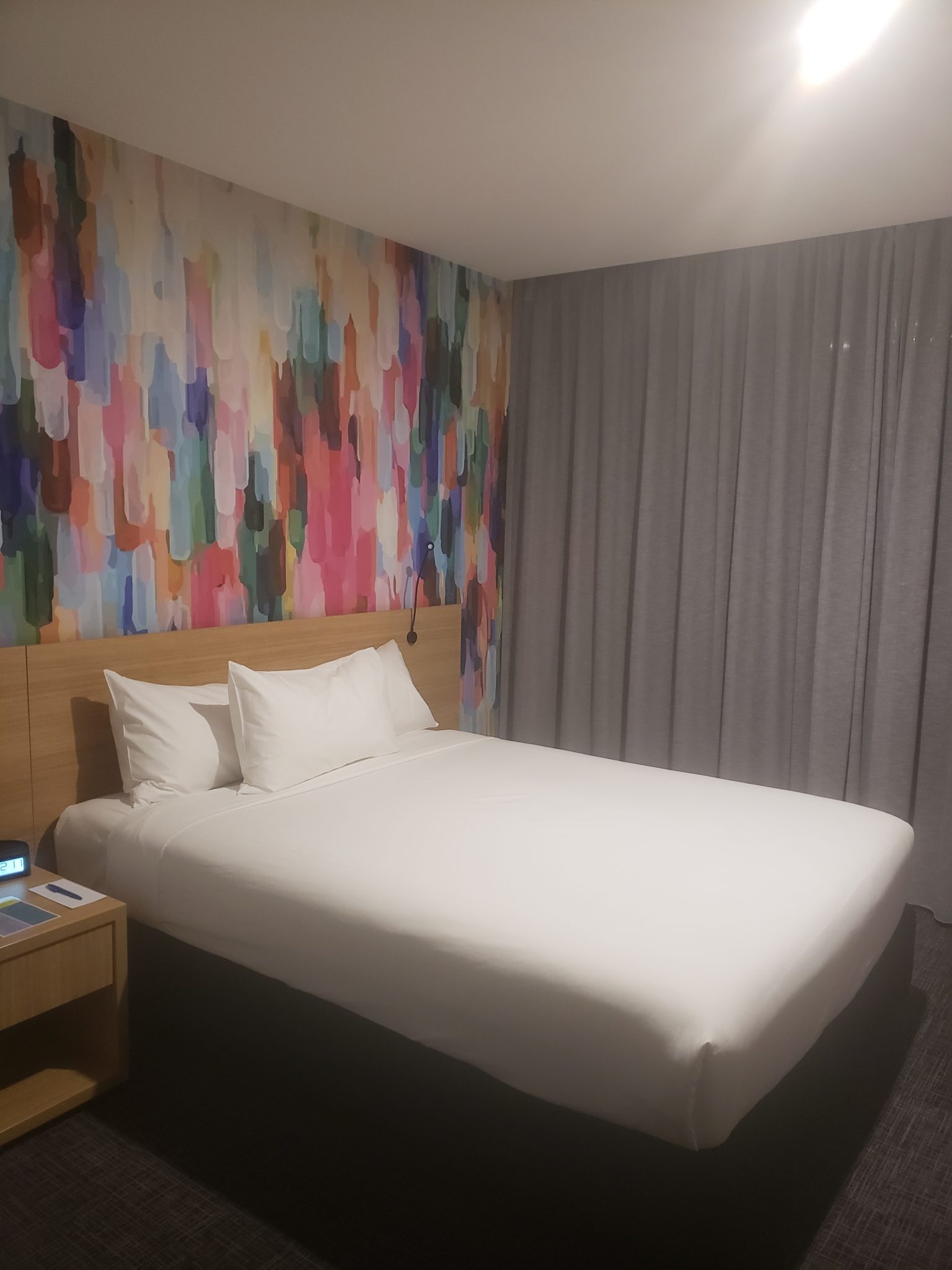a bed with a colorful wallpaper