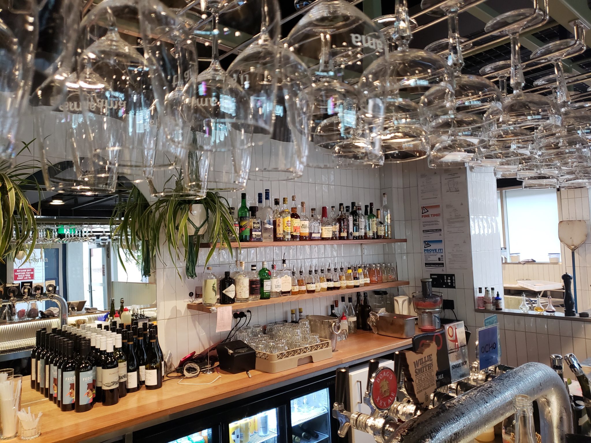 a bar with wine glasses from the ceiling