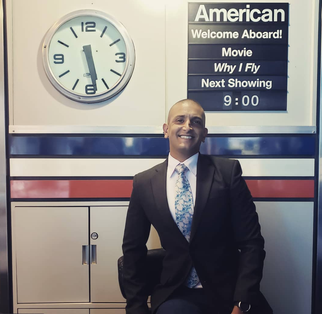 a man in a suit sitting in front of a clock
