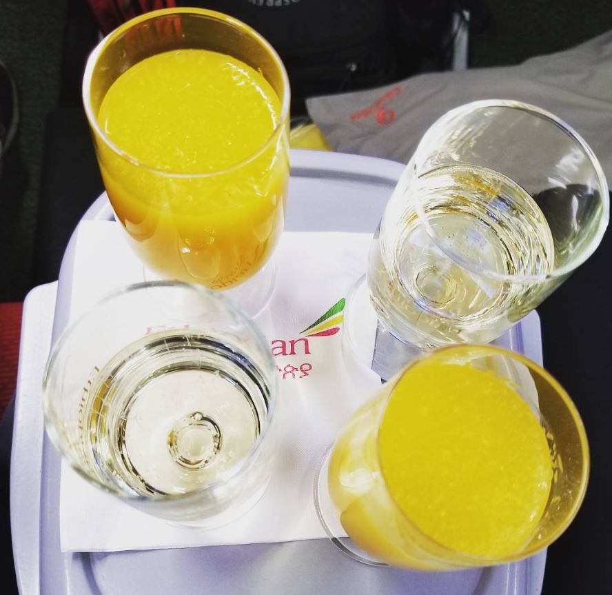 a tray with glasses of liquid and orange juice on it
