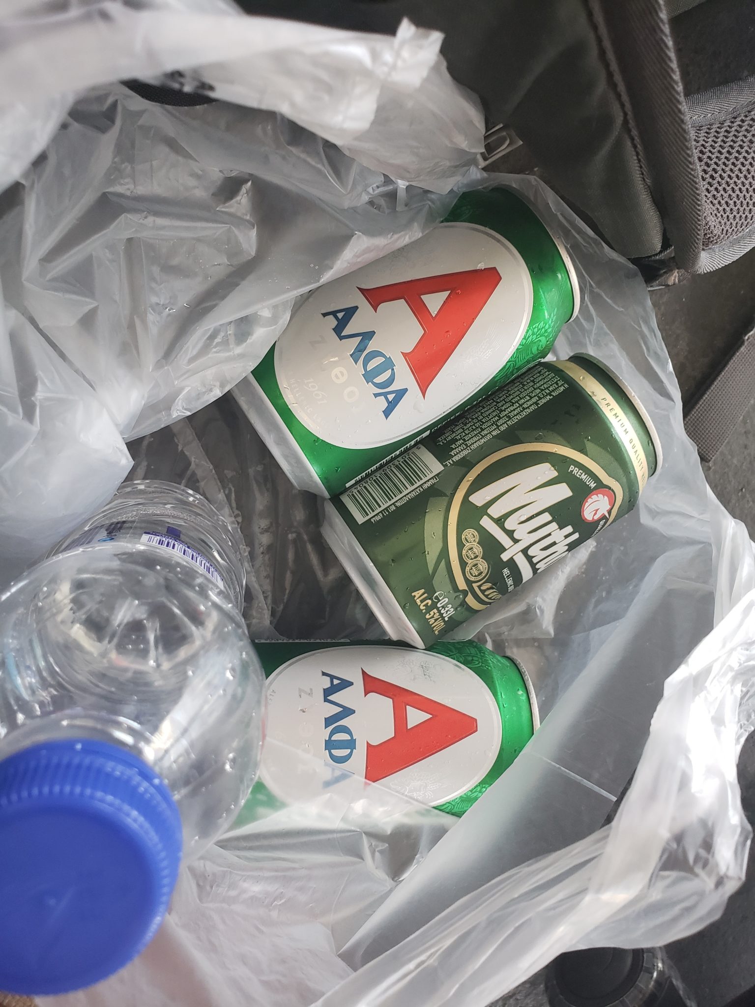 a plastic bag with cans and bottles