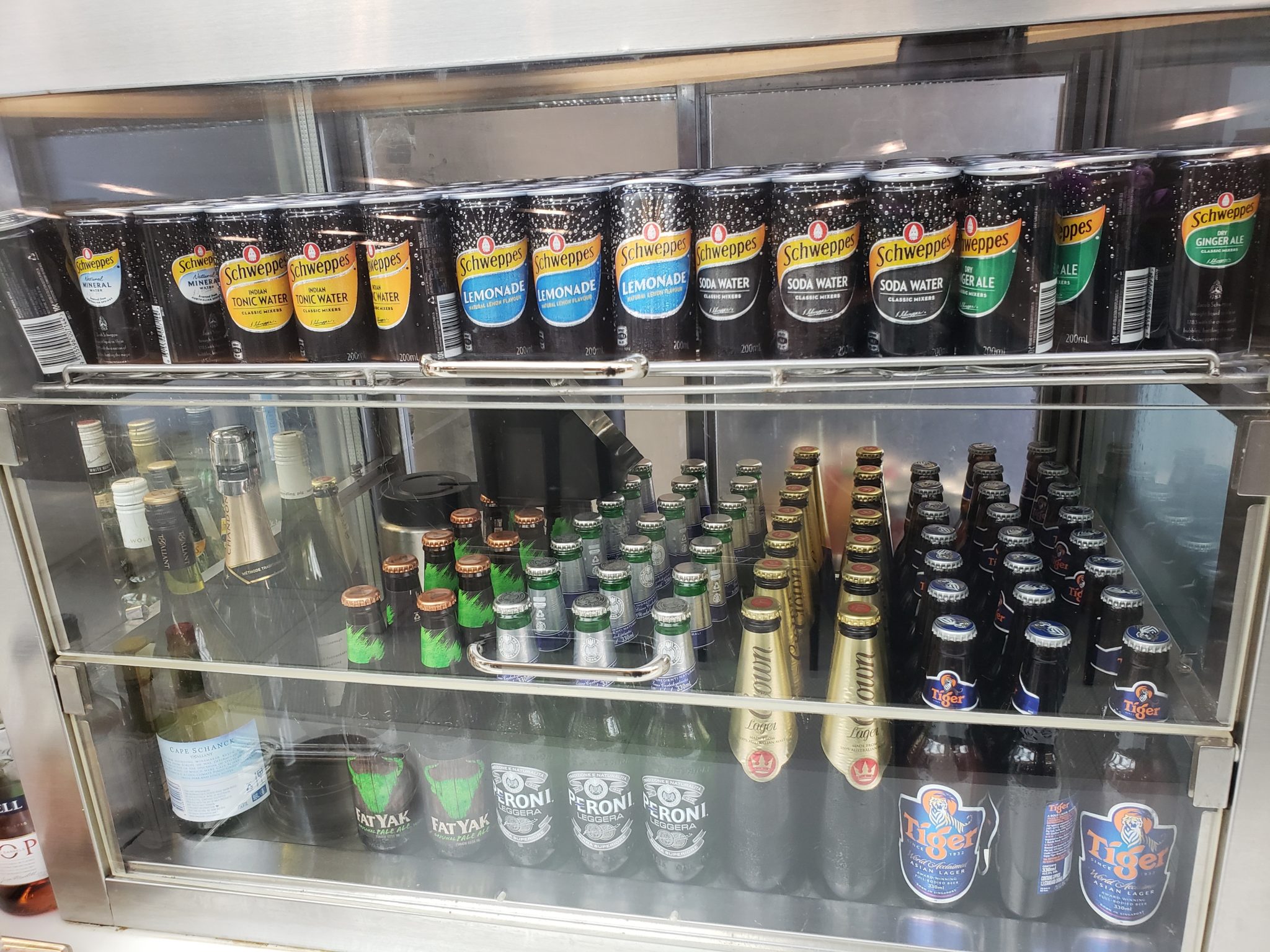 a glass case with several cans of beer