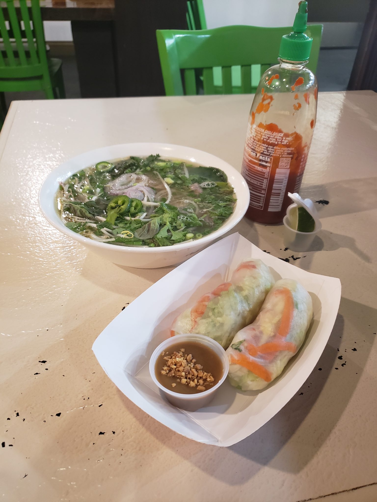 a bowl of soup and spring rolls on a table
