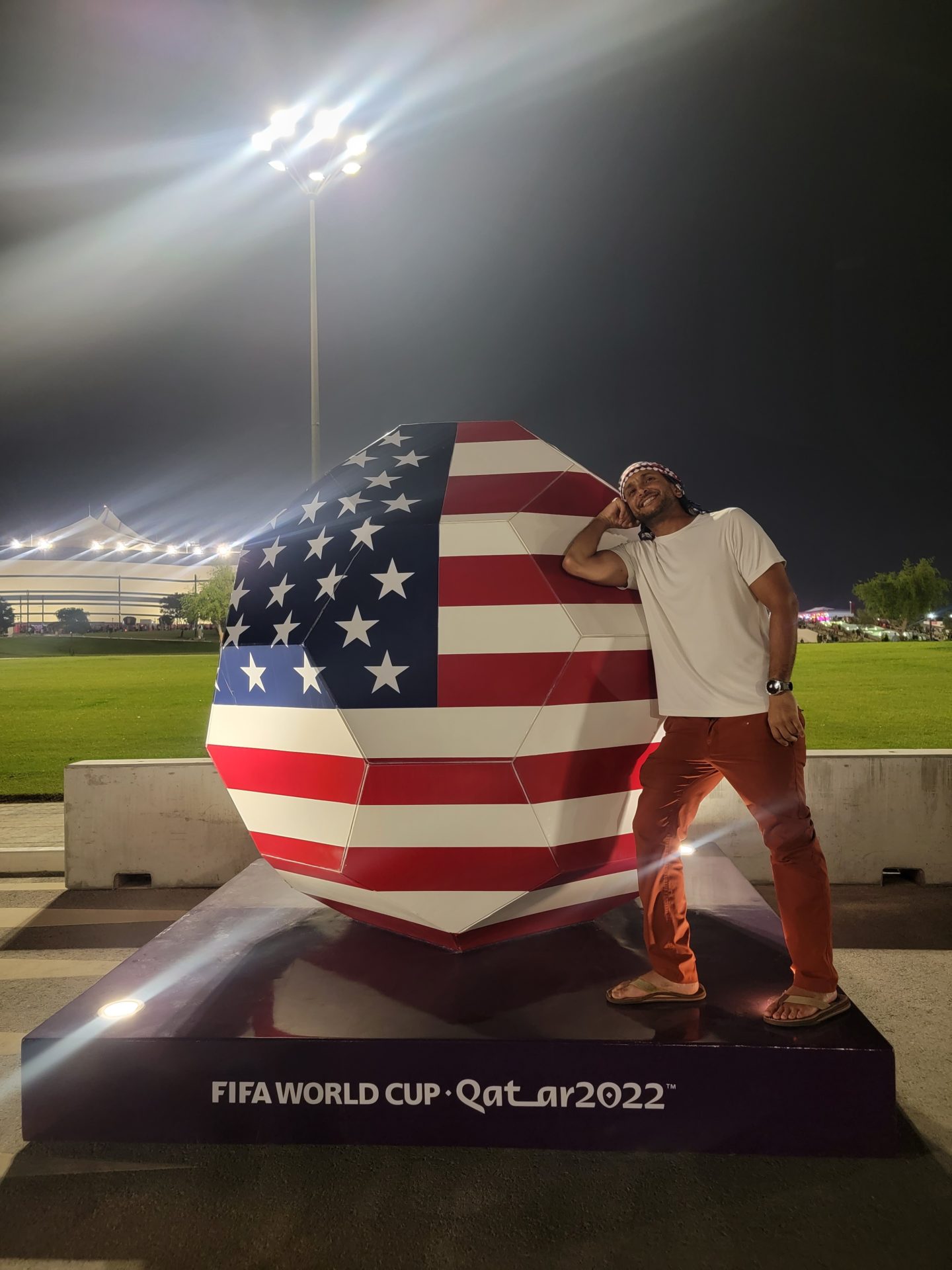 a man standing next to a large football ball