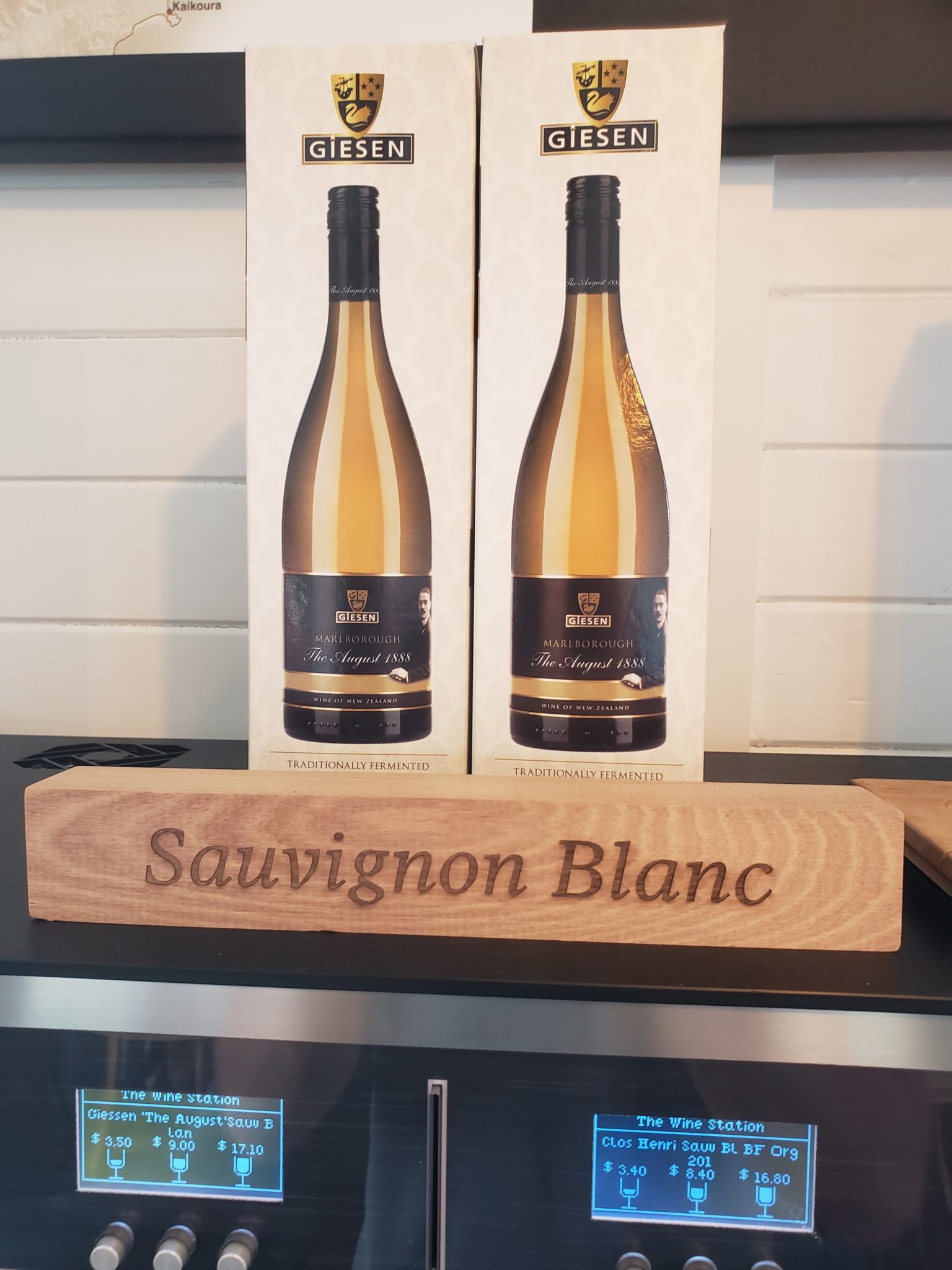 a wooden sign with two bottles of wine