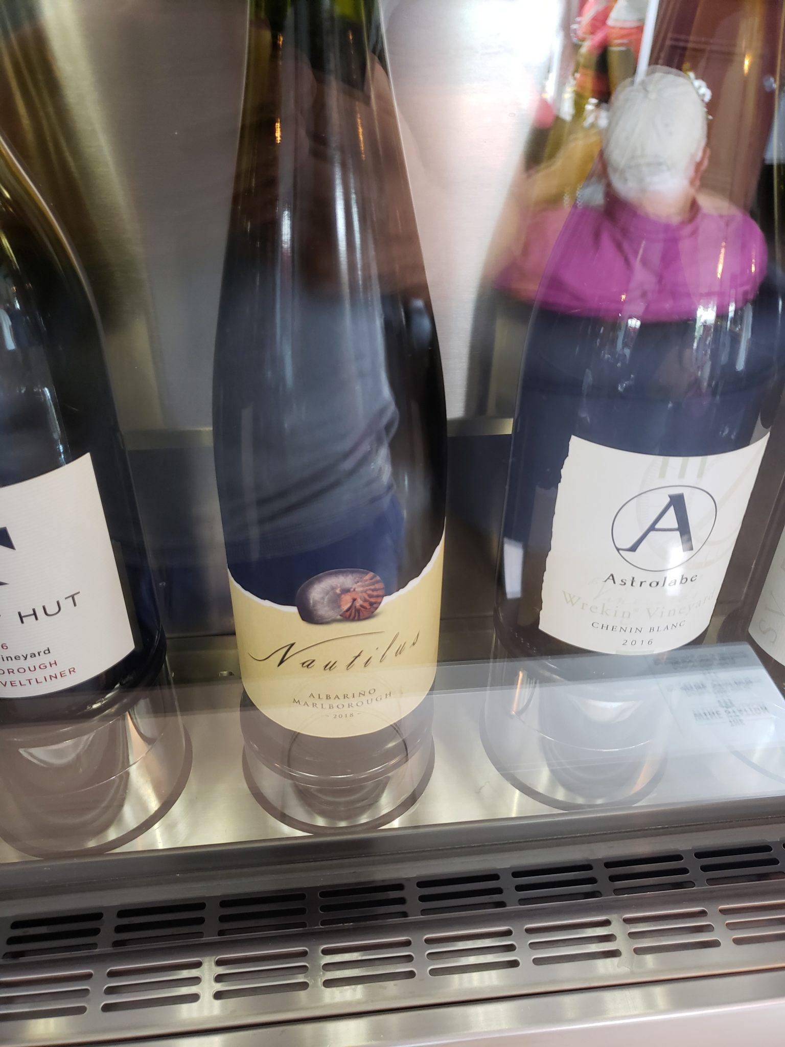 a group of wine bottles in a glass case