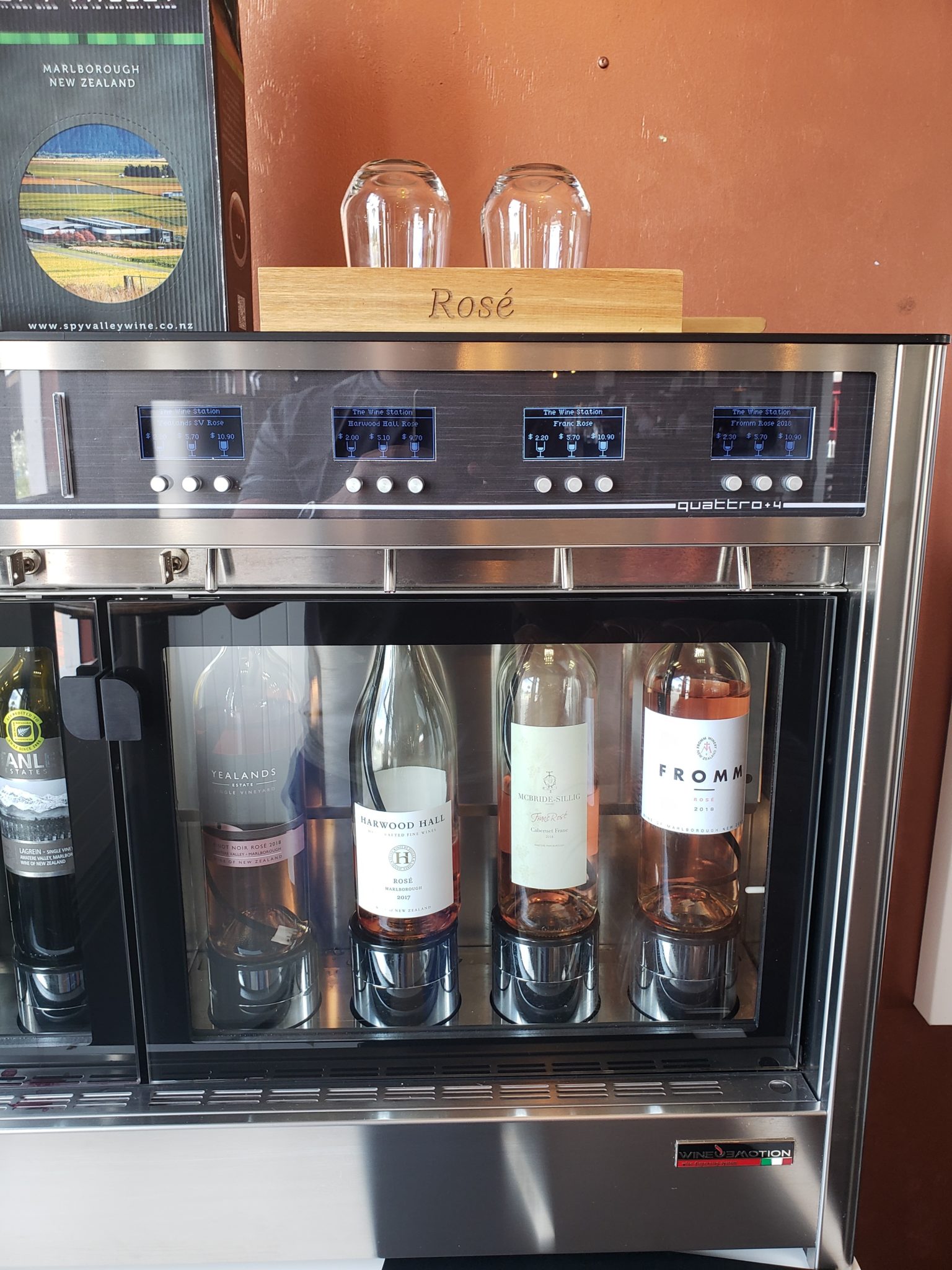 a wine cooler with bottles and glasses