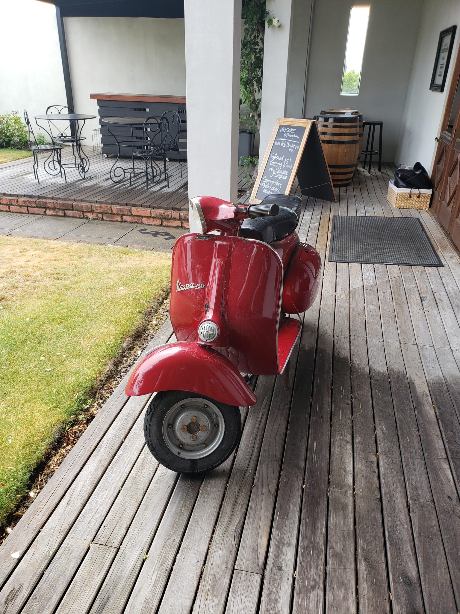 a red scooter parked on a wooden deck