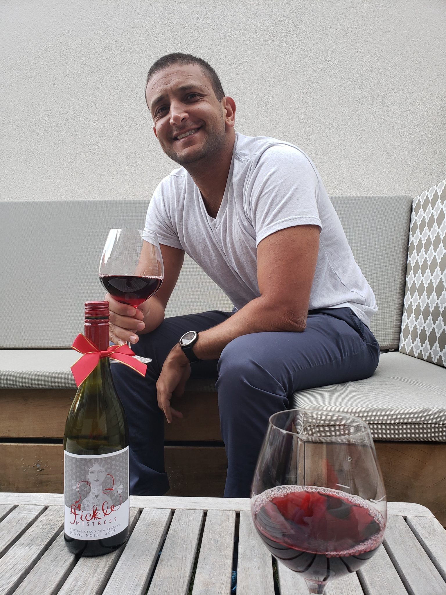 a man sitting on a couch holding a glass of wine