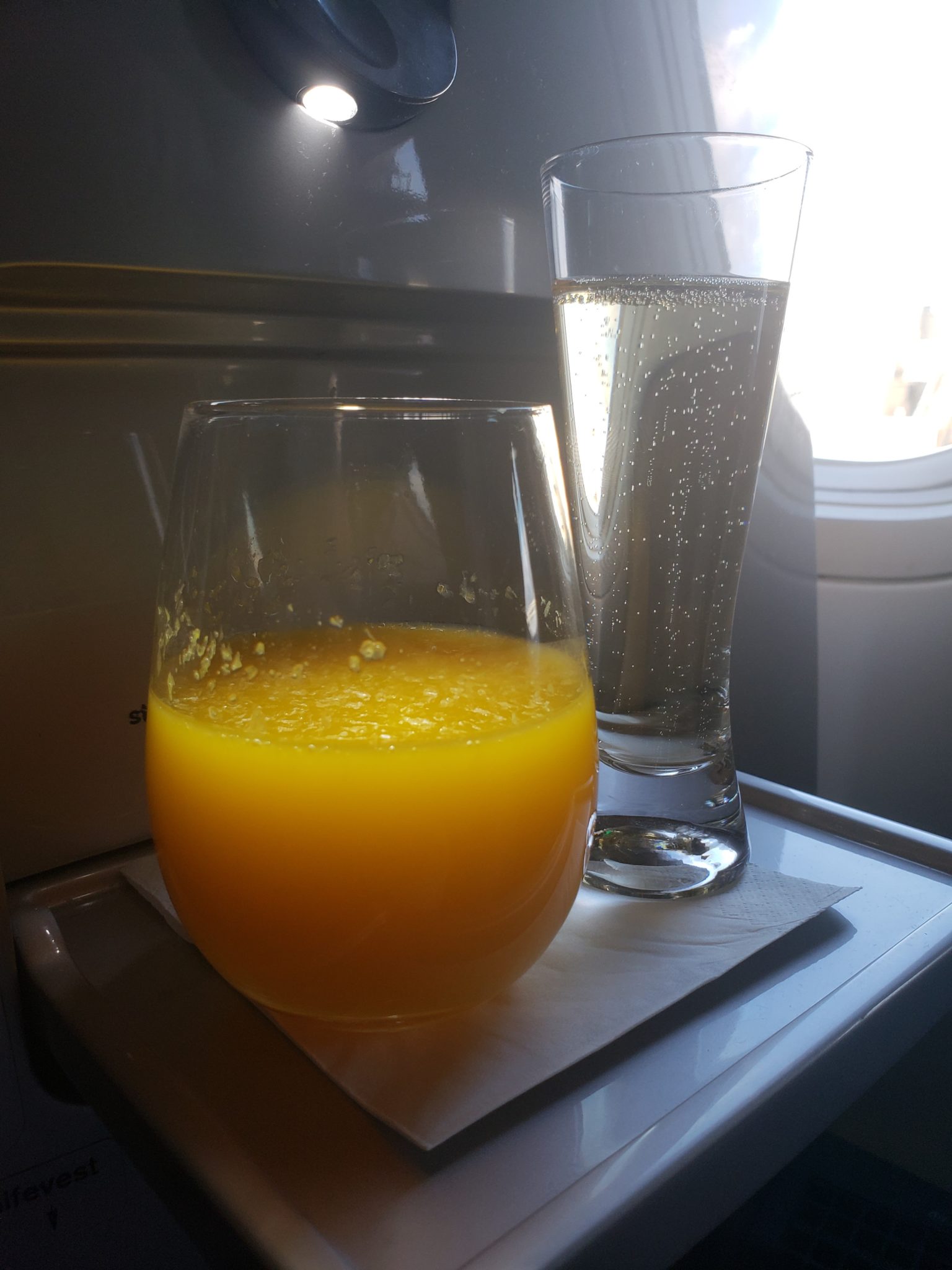 a glass of orange juice next to a glass of water