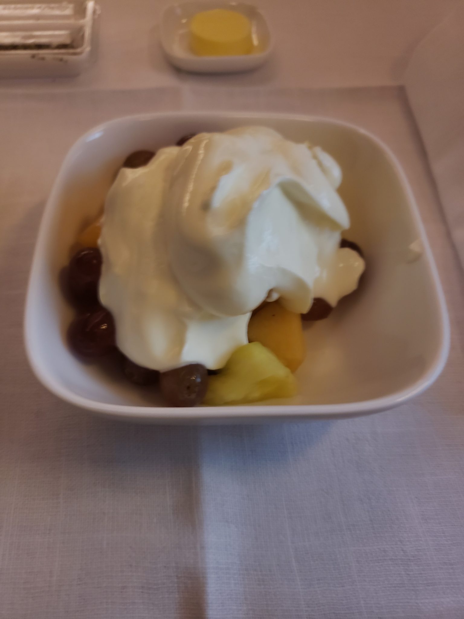 a bowl of fruit with whipped cream