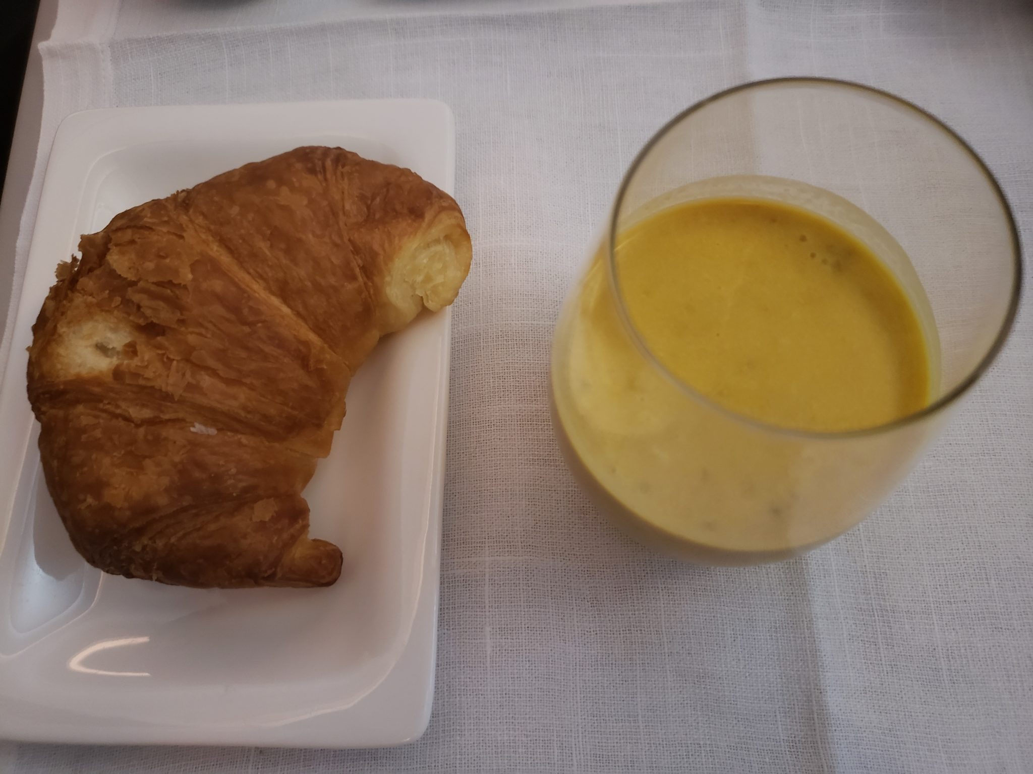 a croissant and a glass of liquid