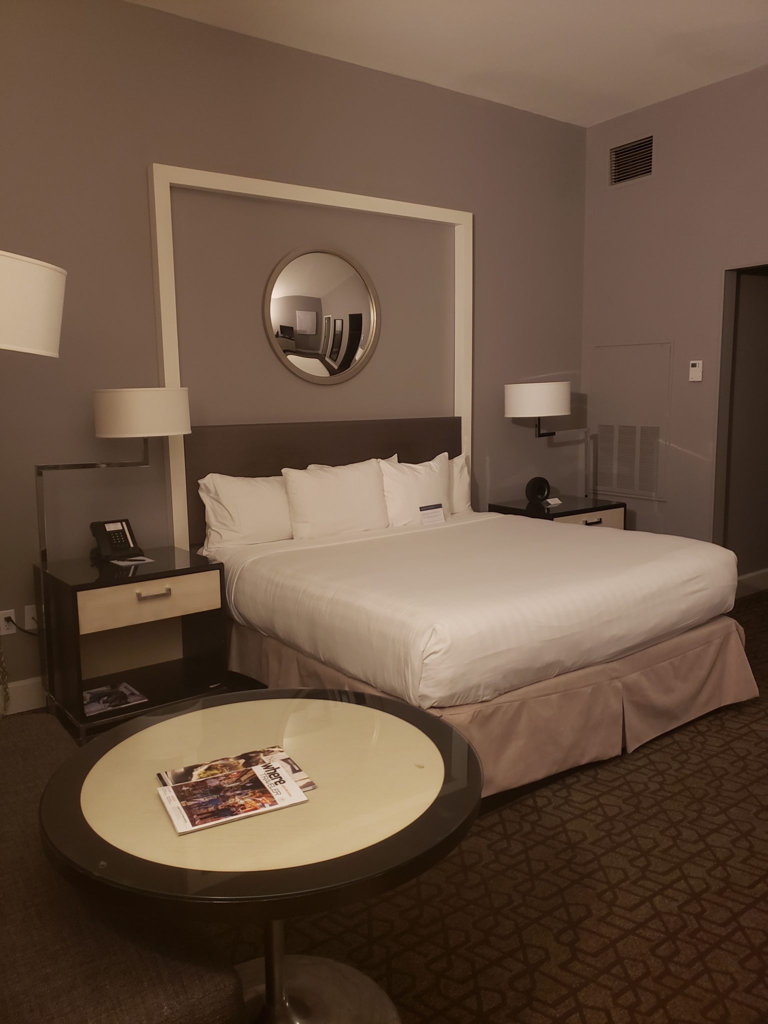 a hotel room with a round table and a bed