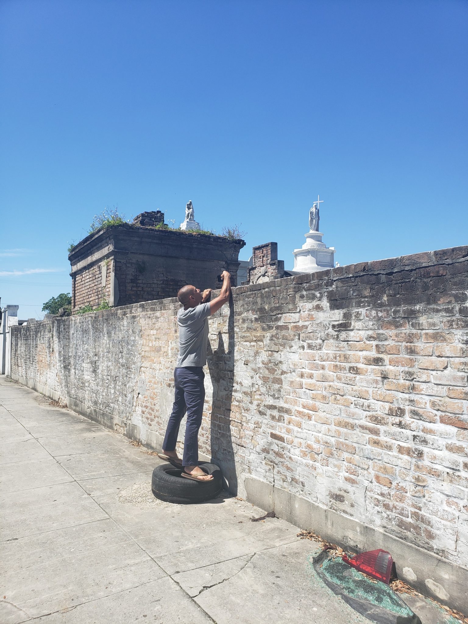 a man standing on a tire on a brick wall