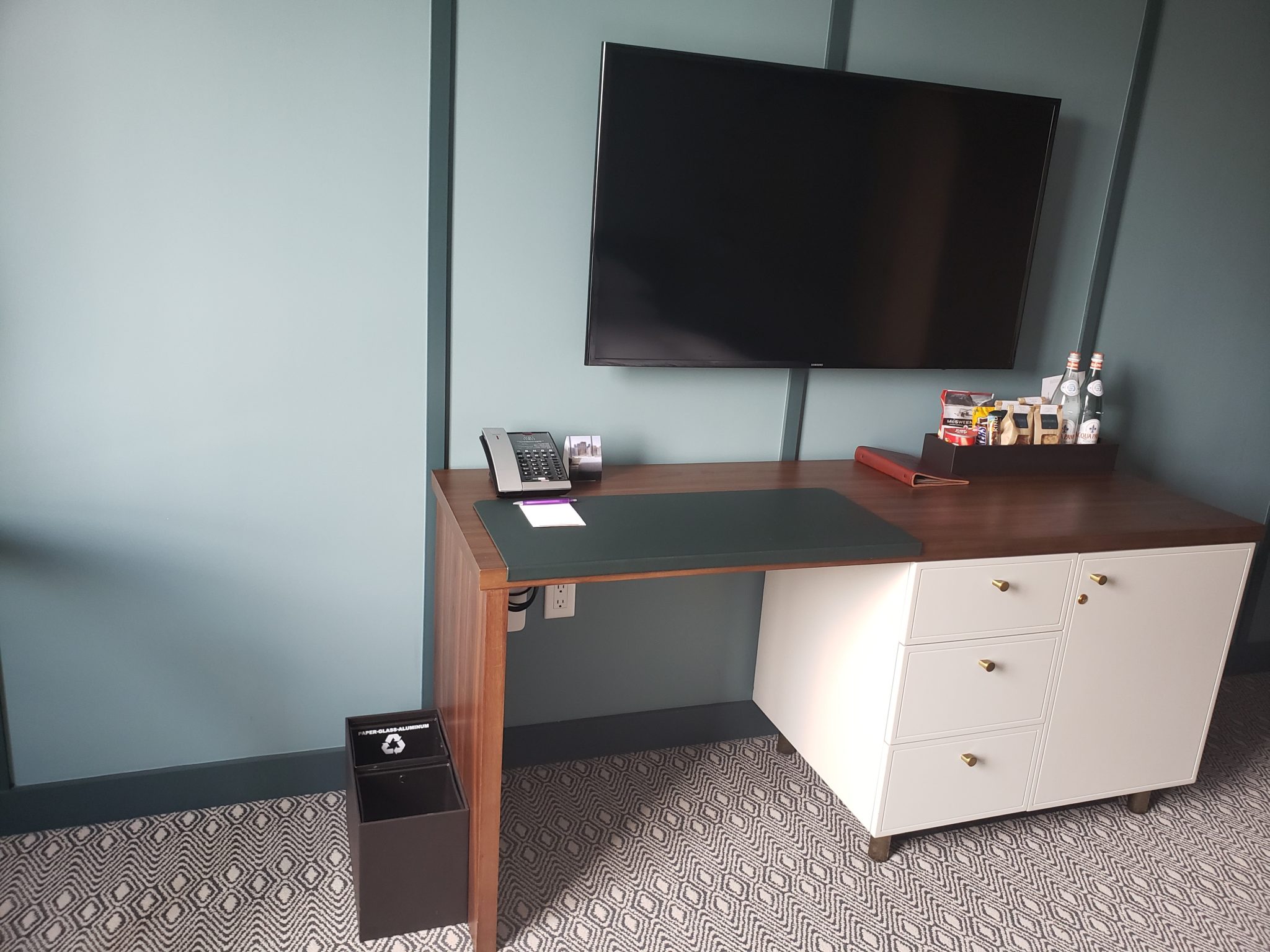 a desk with a television on the wall