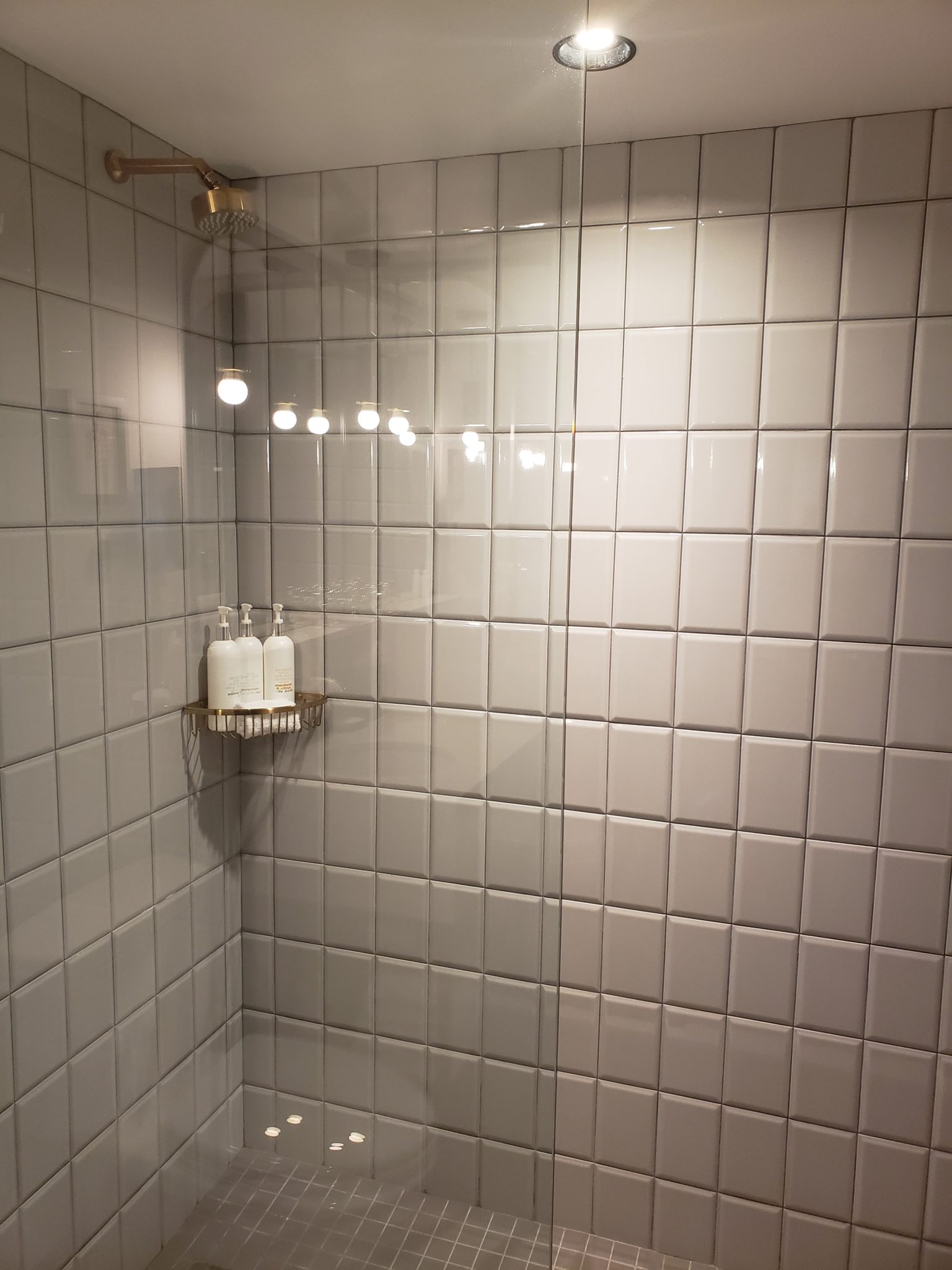 a shower with white tiles