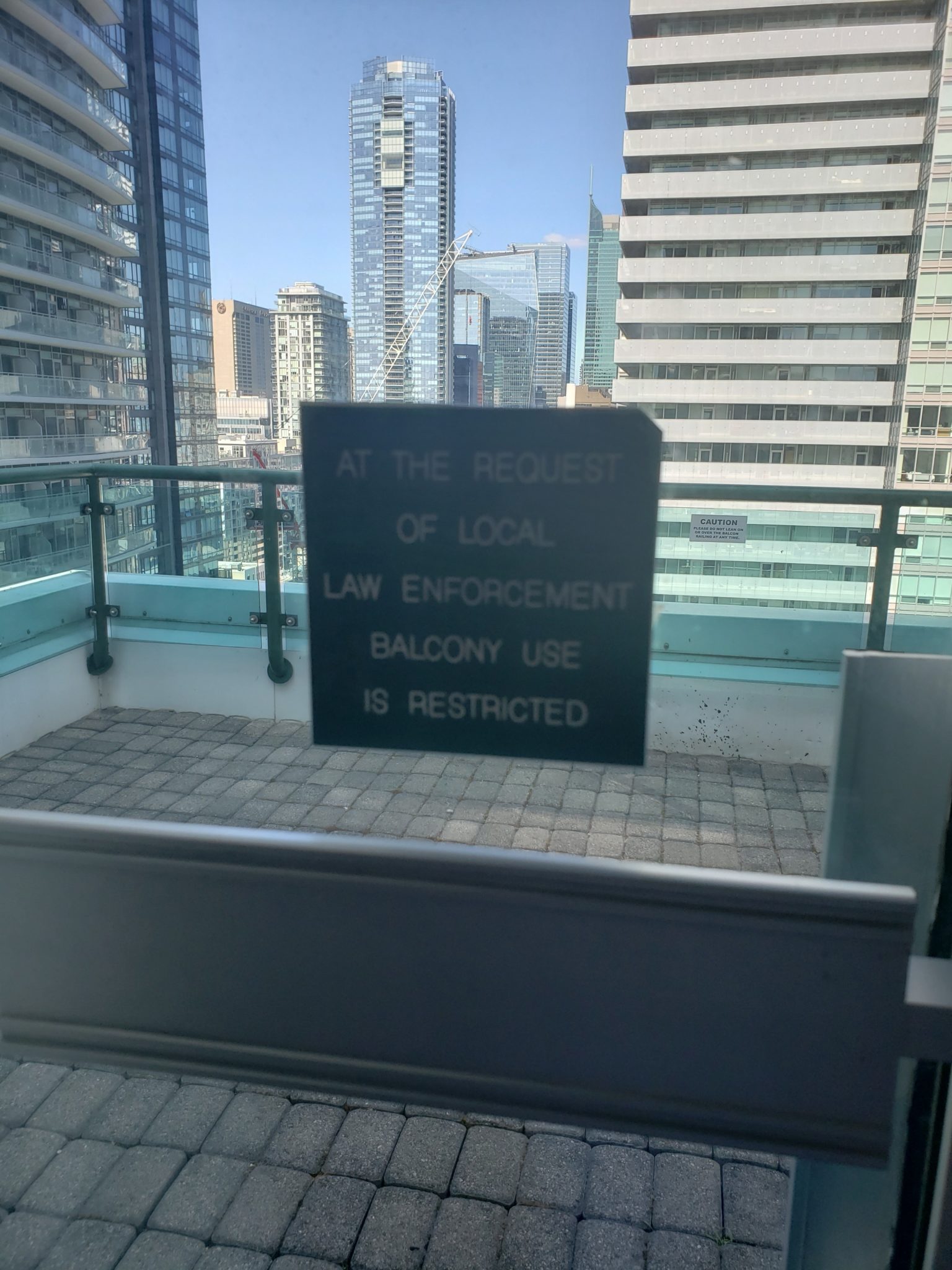 a sign on a balcony with a city skyline in the background