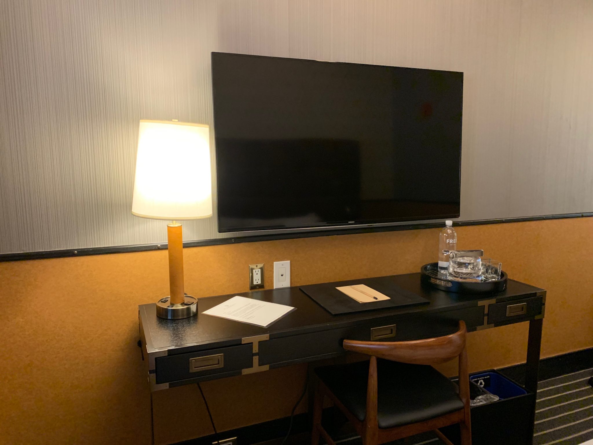 a desk with a lamp and a television on it